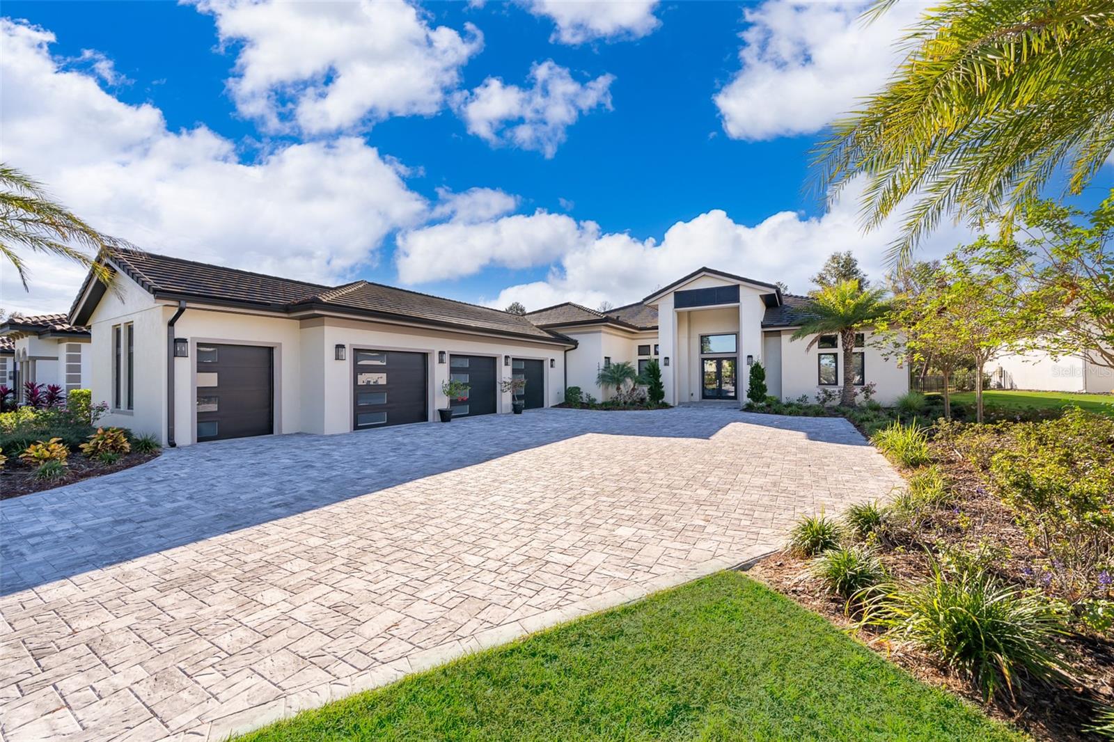 Experience refined luxury living in this stunning contemporary custom residence located within the well-know  gated community of Bella Collina. Professionally and impeccably designed, this move-in ready home blends sophistication, comfort, and functionality with thoughtfully curated upgrades throughout. Flooded with natural light, the expansive open-concept floorplan showcases soaring ceilings, oversized porcelain tile flooring, and impressive 10-foot sliding glass doors that seamlessly connect indoor and outdoor living spaces.

The gourmet chef’s kitchen is beautifully appointed with sleek custom cabinetry and premium Thermador appliances, including a 48-inch six-burner gas range, double wall ovens, and a built-in microwave, creating the perfect space for both everyday living and entertaining. The luxurious primary suite offers tranquil views of the private, forest-like backyard and features a fully upgraded spa-inspired bath complete with an oversized walk-in shower, dual vanities, a freestanding soaking tub, and elegant custom wall detailing.

Designed for entertaining, the spacious family/game room opens through double pocket sliding doors to an oversized covered lanai featuring a custom outdoor kitchen and resort-style pool—an ideal setting for gathering with family and friends. The 3.5-car garage provides generous storage and convenient golf cart parking.

Additional enhancements include professional landscape lighting, an expansive paver driveway, and water softener system, and a whole-home lightning surge protector installed in 2025 for added comfort and peace of mind.

Residents enjoy access to Bella Collina’s exceptional amenities, including the Nick Faldo-designed 18-hole championship golf course, Har-Tru tennis courts, pickleball courts, resort-style pool complex, fitness center, luxury spa, complimentary fitness classes, and year-round social and culinary events.

Discover elevated living in one of Central Florida’s premier private golf communities—schedule your private showing today.