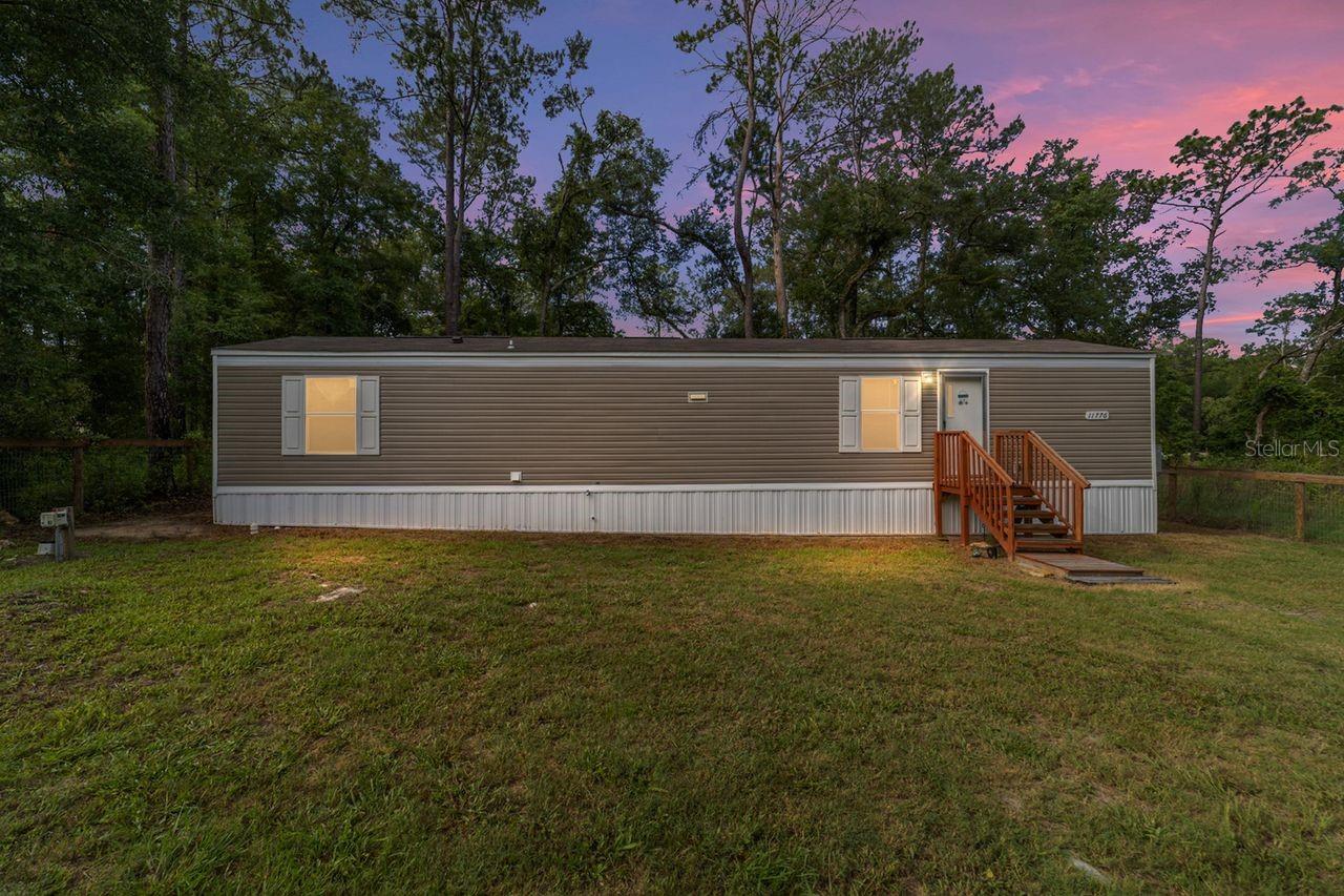 Virtually Staged. Welcome home to this beautiful 2024 manufactured home situated on approximately one-third of an acre in NW Ocala. This
move-in ready property offers the perfect opportunity to own your own land while enjoying the comfort of a like-new home. Nestled
among mature trees, the backyard provides added privacy and a peaceful setting, all while being located on a quiet paved road. The
home features an open-concept floor plan with a split-bedroom layout, offering 2 bedrooms and 1 full bathroom. There is no carpet
throughout, providing a modern look and easy maintenance. A brand-new washer and dryer are included, making this home truly
move-in ready. The property is completely fenced, with a newer fence installed in November 2024, offering privacy, security, and
plenty of space to enjoy outdoor living. Best of all, there is NO HOA, giving you the freedom to enjoy your property without additional
fees or restrictions. Conveniently located just minutes from the World Equestrian Center, shopping, restaurants, hospitals, and
everyday amenities, this home offers the perfect balance of peaceful country living and modern convenience. Motivated Seller!
Whether you're a first-time homebuyer, looking to downsize, or searching for an investment opportunity, this property is an excellent
choice. Don't miss this opportunity to own a like-new home with your own land. Schedule your private showing today!