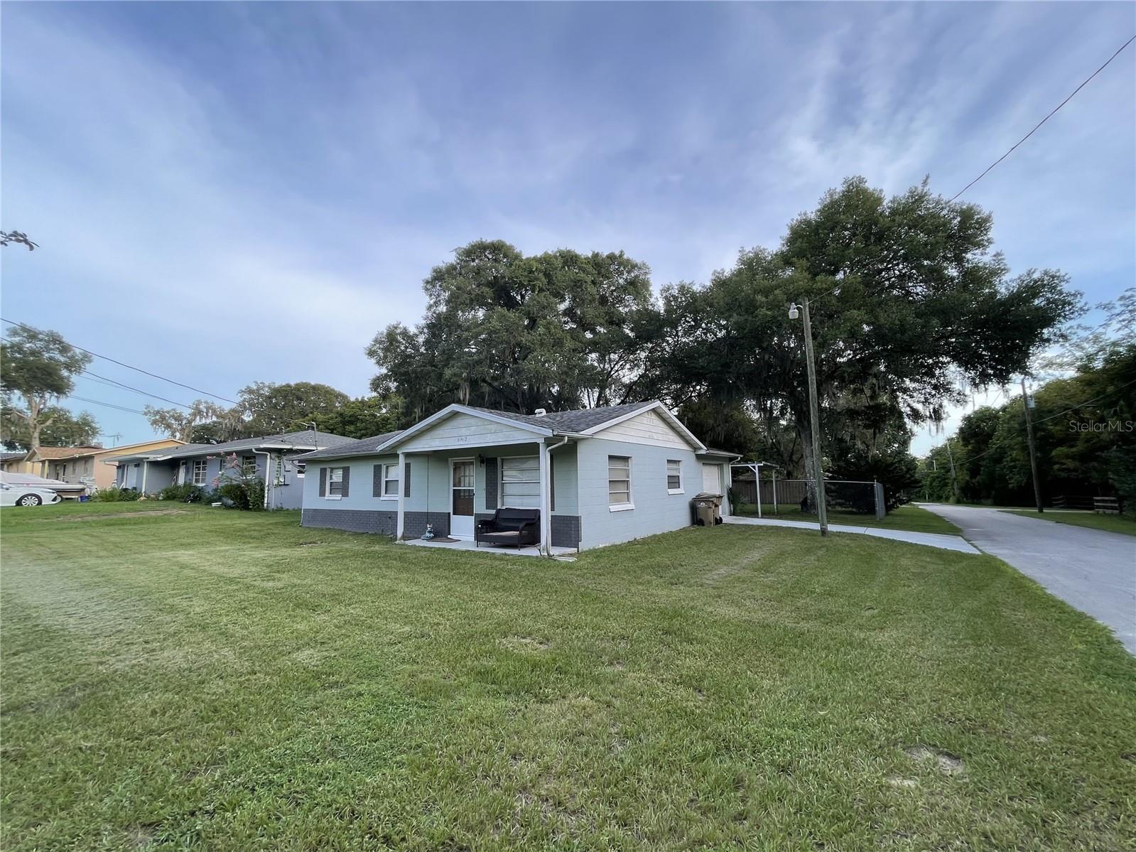 Sunnyside Home in Leesburg - Lovely 1,832+/- SF  3/2  block home on large corner lot with attractive, fenced in back yard. Located in a quiet little area with no through streets make this a great opportunity if you are just starting out or down sizing. Just minutes to UF Health Leesburg or a short drive to UF Health The Villages or Tavares Advent Health Waterman. Home has garage and a carport. Seller has updated both  bathrooms with new tile  as well as tile floors in the living room, kitchen and dining area. Property is on well and septic. NO HOA so no problem for your boat or RV. Less than an hour from Orlando and minutes to world class golfing or fishing on the Harris Chain of Lakes. Washer and Dryer do not convey, Roof went on in 2012, new drainfield 2015, New A/C July 2023 & septic pumped out Aug 2023.  Easy to see with appointment.