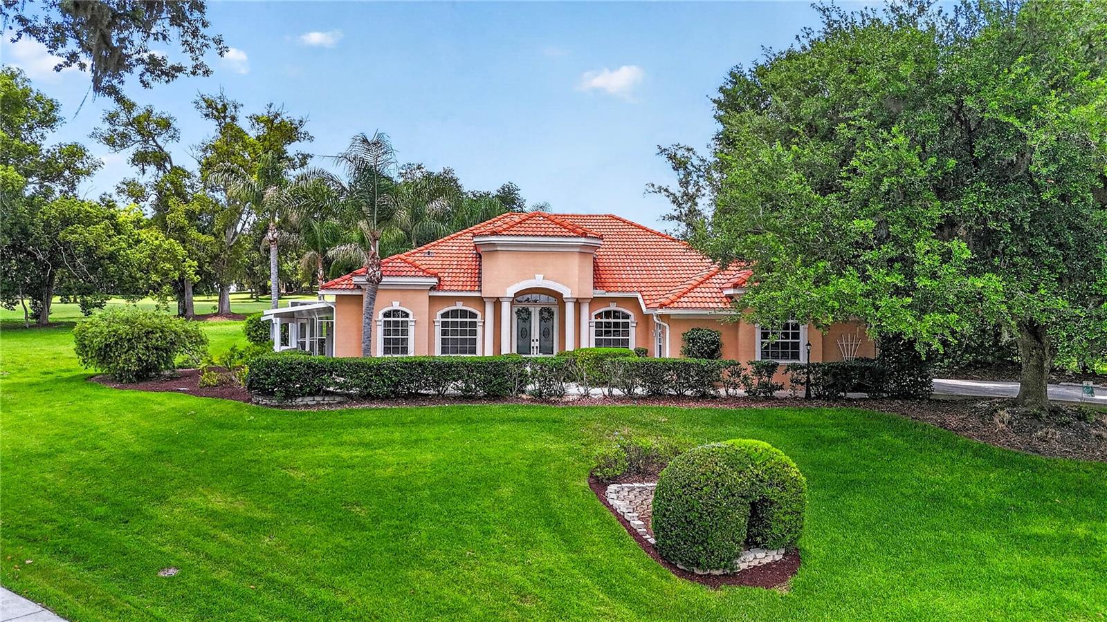 One or more photo(s) has been virtually staged. Welcome to luxury living in the renowned Lake Jovita Golf & Country Club, nestled among the breathtaking rolling hills of Dade City. Perfectly positioned on an expansive and rare 0.8-acre homesite, one of the largest lots in Lake Jovita outside of the exclusive Estates, this exceptional 4-bedroom, 3-bath pool home offers elegance, privacy, and timeless design in one of Pasco County’s most sought-after gated golf communities.
From the moment you arrive, the stately side-entry 3-car garage, lush landscaping, and impressive curb appeal create a warm and inviting first impression. Inside, the thoughtfully designed split-bedroom floor plan offers both functionality and flexibility, including a private in-law suite with its own entrance, ideal for guests, multigenerational living, or a private retreat.
Beautifully updated throughout, the home showcases luxury wood-look tile flooring, timeless finishes, and an abundance of natural light. Formal living and dining rooms provide elegant entertaining spaces, while the private office with French doors offers the perfect work-from-home setup. At the heart of the home, the spacious kitchen features stainless steel appliances, updated backsplash, wine serving area with built-in wine storage, oversized walk-in pantry, breakfast nook, and generous cabinetry designed for everyday living and entertaining alike.
The owner’s suite is a true retreat, complete with sliding glass doors leading to the outdoor patio, dual walk-in closets, and a luxurious 5-piece ensuite bath designed for relaxation and comfort. Two additional guest bedrooms share a well-appointed bath, while the separate in-law suite adds exceptional versatility rarely found in today’s market.
Step outside into your own private resort-style oasis where Florida living truly shines. The expansive screened lanai features a sparkling concrete pool and spa with a new electric heat pump, retractable awning, built-in outdoor propane grill, and multiple spaces to lounge, entertain, and unwind while enjoying the privacy of the oversized homesite.
Living in Lake Jovita Golf & Country Club means embracing an elevated lifestyle surrounded by scenic beauty and world-class amenities. Known for its award-winning 36-hole championship golf course, Lake Jovita offers two distinct courses winding through rolling hills, mature oaks, lakes, and stunning natural landscapes rarely found in Florida. Residents enjoy access to a beautifully appointed clubhouse, fitness center, tennis and pickleball courts, resort-style swimming pool, dining and social events, and a welcoming country club atmosphere that makes every day feel like a getaway.
Conveniently located just north of Tampa with easy access to I-75, yet tucked away in the charm and tranquility of Dade City, this remarkable property offers the perfect blend of luxury, privacy, and lifestyle. Opportunities like this, on one of Lake Jovita’s largest homesites, rarely come available.