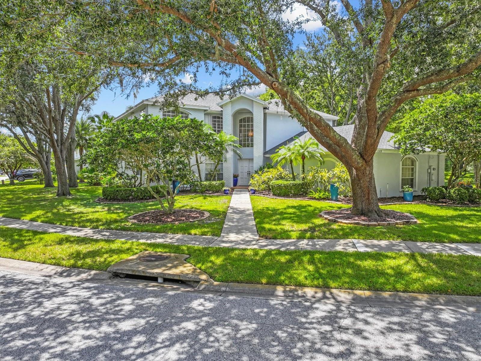 Welcome to the charming Warwick Hills enclave within the desirable Eastlake Woodlands community! Enjoy the peaceful drive home beneath beautiful tree-canopied streets, where this exceptional two-story residence awaits on one of the largest corner lots in the neighborhood. Perfectly elevated and high & dry, this home has never experienced standing water. A stately presence greets you with elegant landscaping, including a brand new row of privacy hedge plants & palms surrounding the pool enclosure. Side-entry 3-car garage, and an extended driveway offering ample parking. Step inside through double doors into a grand foyer with soaring ceilings.The entire interior was freshly painted in May 2026. The thoughtful layout includes formal living and dining rooms, as well as a spacious family room featuring a cozy wood-burning fireplace and sliding glass doors that open to the lanai and sparkling pool. The kitchen and family room blend seamlessly with an open floor plan, highlighted by an island, wet bar, and three pantries, two are oversized pantry closets—ideal for both everyday living and entertaining. From here, enjoy relaxing views of the pool, jetted spa( not heated) , and backyard, where you may even spot deer strolling through. A versatile office on the main floor can easily serve as a 5th bedroom, complemented by a full-size laundry room and powder bath. Upstairs, the expansive primary suite welcomes you with double-door entry, generous space for king-sized furnishings, and a private sitting area. The suite also offers two walk-in closets and a stunning, brand-new freshly renovated bathroom with a soaking tub, dual vanities, private water closet, and a new glass-enclosed shower. The 2nd floor also features 3 more bedrooms and 2 more full baths. Additional updates include a freshly painted exterior (2023), roof (2022), A/C units (2018 & 2019), hurricane shutters for all windows & doors, accordion shutters for sliding glass doors, fresh carpet on staircase, water heater (2018) ensuring peace of mind for years to come.  Ardea Country Club has recently been updated. Residents can take advantage of premier golf, tennis, dining, and social memberships. With easy access to Hillsborough and Pasco counties, this centrally located home is just minutes to shopping, dining, top-rated schools, and all that the Tampa Bay area has to offer.
