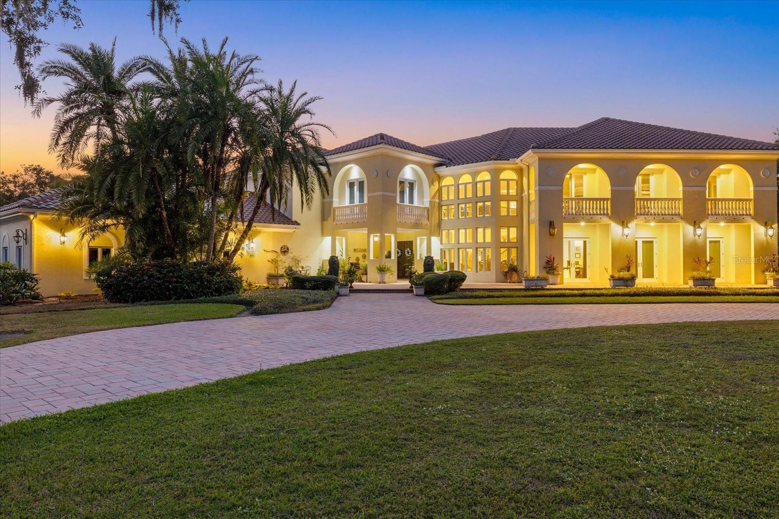 Set behind a private gated entrance and approached by a sweeping drive that curves around the front pond, this 5.6-acre Sarasota estate offers privacy, size and distinction, along with a long list of high-end improvements. upgrades include a 2025 roof, brand-new whole-home generator, comprehensive smart-home systems, a new pool deck with pavers and turf, 4-hole putting green, new outdoor kitchen, refreshed irrigation well (2024), reverse-osmosis well system, 5 AC units, 2 gas tankless water heaters, 2 in-ground propane tanks, 500 Gallon RO Tank, a 1450 aeroator tank, and refined interior details such as Venetian plaster walls and custom cherry wood in-lay flooring in the game room loft area. The result is a property that feels both luxurious and exceptionally well cared for. Beyond the upgrades, the home offers more than enough space for large-scale living and entertaining. The main living areas are anchored by a 24-foot high ceiling in the great room, a dedicated theater room, and an expansive game room/loft area with full bar, balcony, and additional loft space. Smart-home features include a phone-controlled gate system, whole-property cameras, Sonos audio, smart garage access, and an integrated alarm system. The primary suite occupies its own wing, designed with two oversized walk-in closets, a private exercise room with sauna, and a spa-like bathroom featuring a jacuzzi tub, dual sinks, and a large shower with double heads and body sprays. Four additional en-suite bedrooms include features such as private balconies, outdoor entrances, oversized closets, and a convenient laundry chute. Each bedroom offers generous square footage, giving guests or family members plenty of room to spread out comfortably. Two additional flex rooms offer options for an office, studio, homework area, or additional sleeping space. The kitchen is equipped with GE Monogram built-ins, a Bosch espresso machine, wine cooler, mini fridge, two sinks, and an adjacent formal dining room. Additional interior features include a 3-car garage with specialty flooring and storage systems plus an EV Charger, a dedicated dog spa room, homework/craft/sewing room, separate fenced run, extensive cabinet storage, two staircases, and a spacious laundry room with desk nook. Outdoor living has been fully modernized with a redesigned pool area, electric and gas heaters, pool bath and changing area, and outdoor shower. The property also offers the rare ability to add two additional structures, along with a scenic pond, mature landscaping, and abundant wildlife. Location is another standout feature. While the estate feels tucked away and exceptionally private, it sits just minutes from I-75, offering quick access to the greater Sarasota region. Downtown Sarasota is an easy drive at roughly 10–12 miles, Siesta Key Beach is about 15 miles away, and travel is convenient with SRQ Airport approximately 15–20 miles and Tampa International Airport about 55–60 miles from the propertyThis blend of privacy, acreage, and proximity to everything is truly rare—allowing you to feel worlds away while staying connected to the best of Sarasota.  Call for a private tour today.