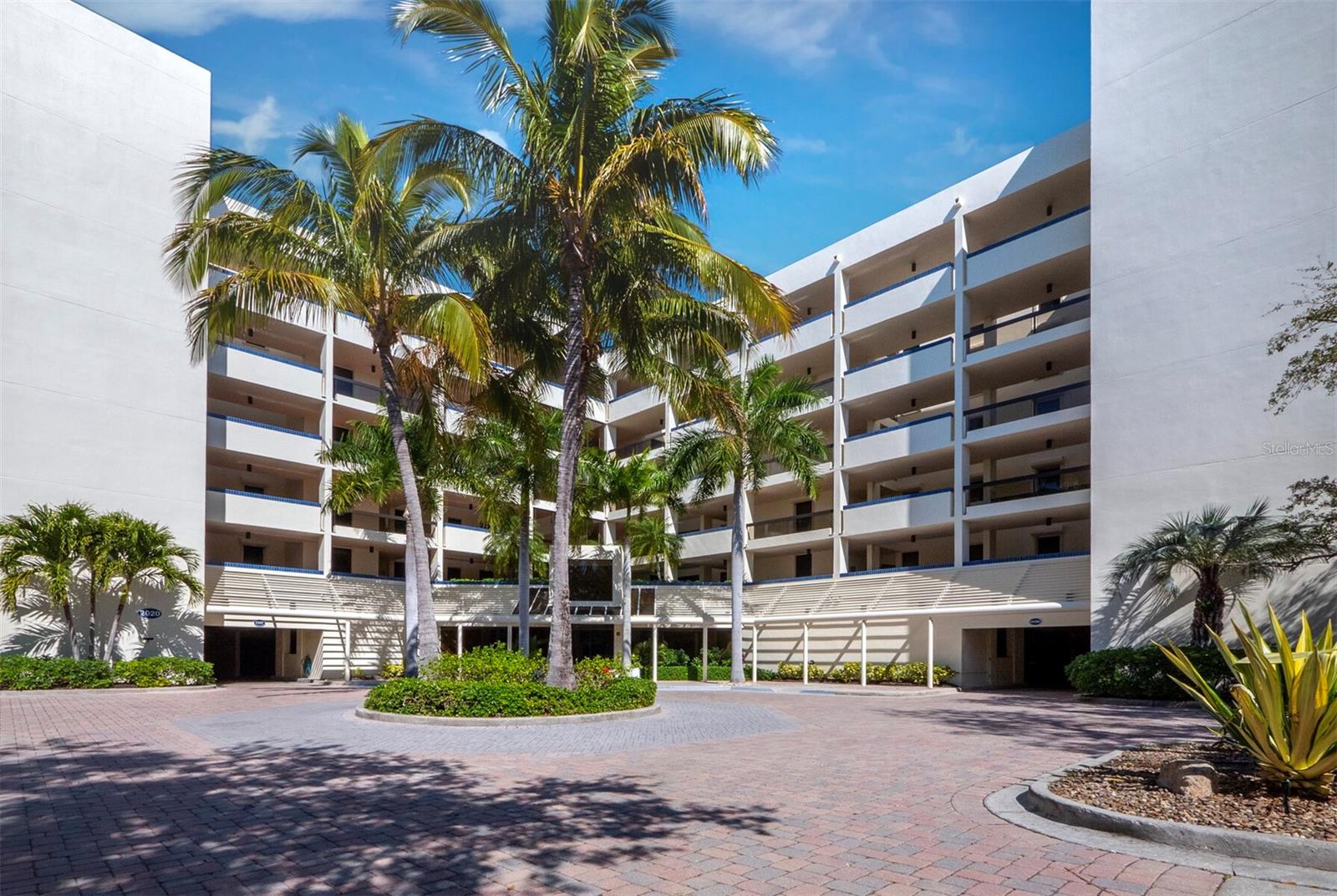 A vibrant expression of style and care, this 2BR/2BA corner residence set on the first living level of Fairway Bay offers 1,715 +/- sq. ft. of thoughtfully designed space in one of Longboat Key's most amenity-rich communities behind the gates of Bay Isles. From the moment you step inside, the attention to detail is clear, creating an interior that feels both polished and inviting. Luxury vinyl plank floors establish a warm foundation, complemented by soft sage tones and the natural blues and greens that draw your eye through the living space toward the water beyond. The living room has been expanded to create a more generous gathering space filled with natural light, while additional enclosed space near the kitchen adds flexibility for a private workspace or extended living. The open terrace off the living area offers views across the bay and toward the Sarasota skyline and direct walkdown access to walking trails, a kayak launch, pool, fitness center, and other community amenities, just steps away. The kitchen has been beautifully updated with a charming breakfast bar accented by shiplap, along with stone countertops, all-white cabinetry, stainless steel appliances and a clean tile backsplash. An abundance of storage and a tucked-away workspace add both function and convenience without interrupting the flow. The primary suite is spacious and serene, offering bay views and a thoughtfully redesigned bath with dual vanities, a glass walk-in shower with porcelain tile and epoxy grout. Additional features include plantation shutters and solar blinds, high-impact glass and storm protection on all openings. Residents of Fairway Bay enjoy a full array of amenities, including deeded beach access and a private beach club, 24-hour gated security, pool, tennis and pickleball courts, fitness facilities and all the privileges of Bay Isles living. Optional memberships to the Longboat Key Golf & Tennis Country Club and access to deepwater slips are available. The residence also includes covered parking and accommodates pets up to 15 pounds.
