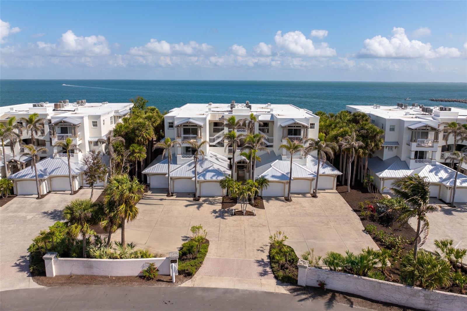Nestled in one of Boca Grande's most coveted waterfront locations, this exquisite Harborshore condominium offers unparalleled bay views and luxury living. Located on the top floor, this 3-bedroom, 3.5-bathroom residence, plus den, presents a stunning open-concept design with elegant coastal style, clean lines, and a warm yet airy color palette. The living spaces have been carefully crafted to maximize breathtaking panoramic views of Charlotte Harbor, neighboring islands, and the wildlife-rich Boca Grande Pass, offering both sunrise and sunset vistas. The fully updated kitchen features custom shaker wood cabinetry, a sleek tile backsplash, Subzero refrigerator, Miele dishwasher, and a Wolf oven & microwave, perfect for the culinary enthusiast. The grand primary suite includes a large bedroom featuring built-in shelving, expansive walk-in closets, and direct bay views from its private terrace and a superbly remodeled bathroom that offers enhanced function with custom cabinetry, stone countertops, abundant storage, and a luxurious expanded shower adorned with beautiful tile work. Premium finishes throughout, including ceiling fans, California Faucets for most plumbing fixtures, and exquisite lighting fixtures complement the home's modern aesthetic. Step outside to impressive bar on the lanai, equipped with 2 Subzero beverage coolers, stunning cabinetry, and a stone countertop, ideal for entertaining or simply enjoying the view.  The generously sized guest bedrooms each offer their own ensuite bathrooms, and the front guest room enjoys its own private terrace with Gulf views. The beautifully designed Harborshore buildings feature welcoming courtyards with fountains, and each residence includes a private one-car garage. Ideally situated near the bay front swimming pool and the renowned fishing pier extending out into the harbor, this community offers an abundance of outdoor enjoyment. Boca Bay is a premier coastal gated community that stretches over 1.5 miles along the waterfront, providing world-class amenities such as clay tennis and pickleball courts, a croquet court, fitness center, three resort-style swimming pools, a lap pool, miles of walking and biking paths, and community boat slips. The community's active and friendly atmosphere is complemented by its exquisite Gulf-front clubhouses offering gourmet dining and bar services. Enjoy an easy and picturesque bicycle or golf cart ride through the Boca Bay community right into downtown Boca Grande.