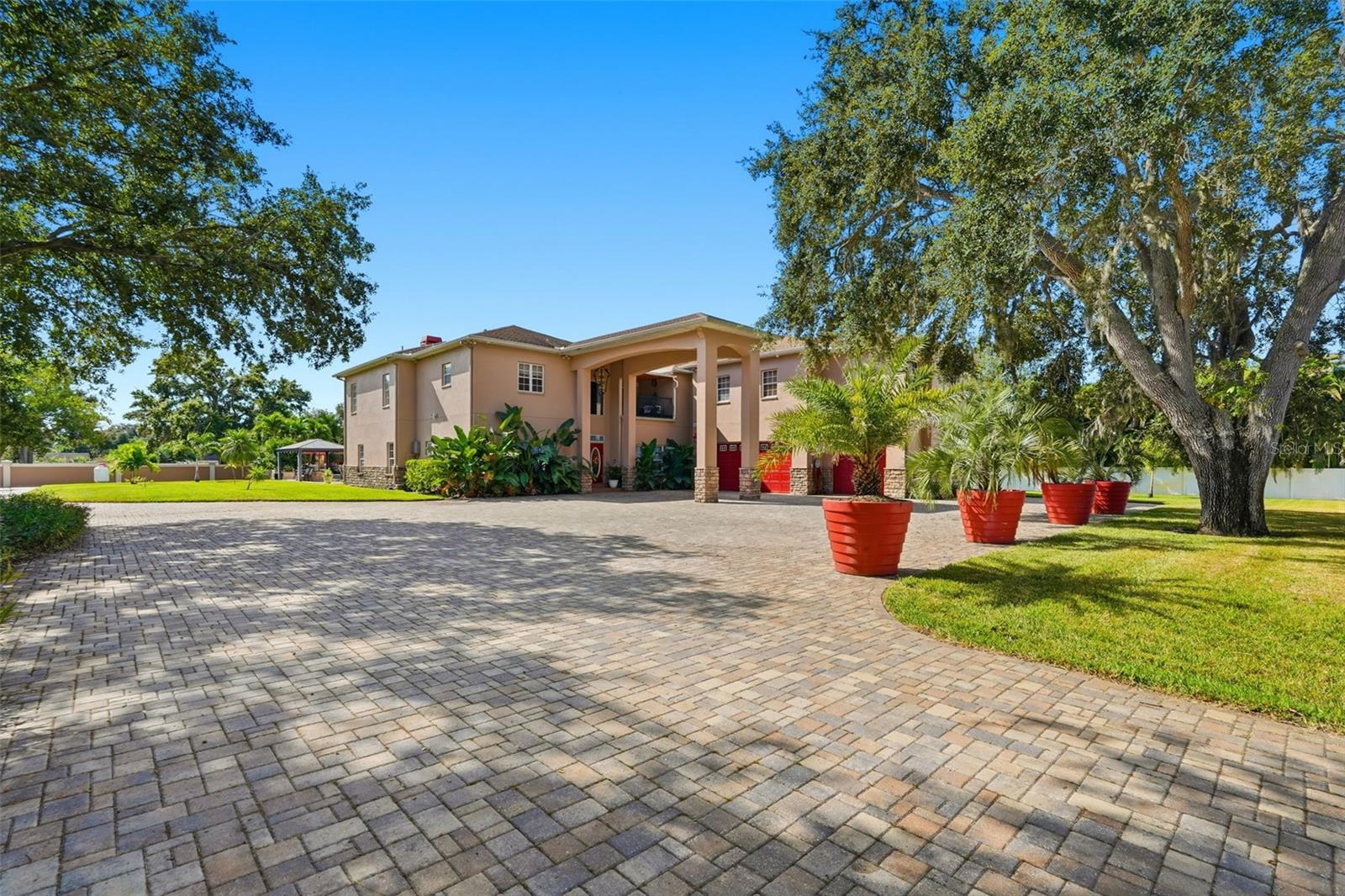 This extraordinary 2.45-acre estate offers a rare combination of luxury living, entertainment, and equestrian amenities just minutes from the beaches—and best of all, it’s not located in a flood zone. The main residence spans over 6,000 square feet with six bedrooms, four full bathrooms, two half bathrooms, a game room, office, and a theater room. An oversized 838-square-foot-attached garage complements the home’s impressive design, while the detached facilities take this property to another level.

Car enthusiasts will appreciate the detached air-conditioned garage, large enough to accommodate up to 20 vehicles, complete with spray foam insulation and a full-length attic above the garage for additional storage. Attached to the garage is a private two-bedroom, two-bath apartment, perfect for guests, staff, or rental income, along with a professional-grade music studio that could easily be converted back to the original racquetball court.

The outdoor living area creates a true resort experience with a sparkling pool and spa, an outdoor kitchen, a tiki bar, firepit area, koi pond, and a dedicated pool house—an ideal space for entertaining or relaxing in complete privacy. For equestrian enthusiasts, this income producing stable has a separate gated entrance with dedicated stable parking with 14 stalls, a feed building, shower stalls, a bathroom, security system, and an arena/jump area. The location is ideal for riding, as the dead-end street leads directly into Walsingham Park with its scenic horse trails.  Homes like this do not become available often, this is a must see property!