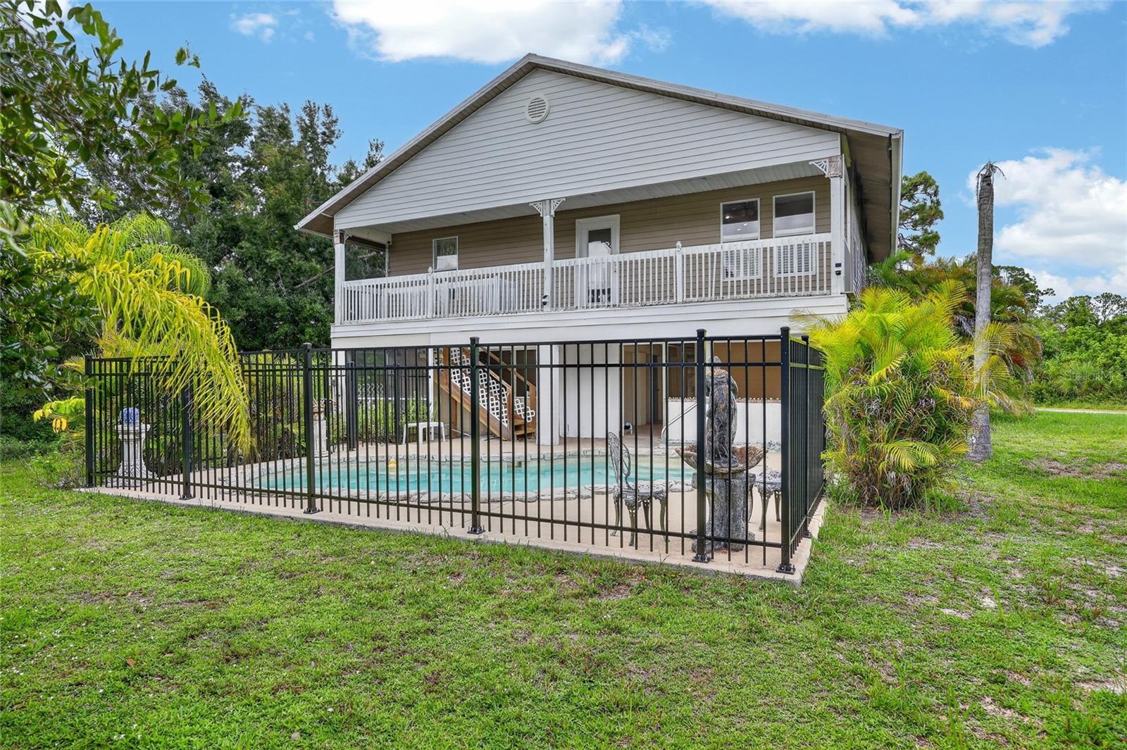 Unique Private Home on Double Lot in Quiet Gulf Cove Welcome to 5220 Anderson Rd, a unique home in the highly desirable Gulf Cove community — offering rare privacy, and located on a double lot! As a Gulf Cove property owner, you have access to the private community boat ramp and waterfront park on the Myakka River. Launch your boat or kayak and enjoy access to Charlotte Harbor and the Gulf
of Mexico in just 5 minutes and a one-mile drive from the house!
This home is in an X flood zone so no flood insurance is required! This sweet home has been updated with a new metal roof, a new energy efficient AC
system, new premium luxury vinyl plank flooring and a new pool fence, all installed in 2023. The living room is cozy with vaulted ceilings. The eat-in kitchen is spacious with beautiful
wood cabinets, a vaulted ceiling, and it flows directly into a spacious family or dining room. There are two bedrooms on the main floor each with its own private bathroom and one with
a jetted tub. Off of the family/dining room is a lovely balcony overlooking the inground pool.
Great for sitting out on at night to star gaze or just to enjoy your morning coffee. The unfinished ground level has a carport for your vehicle and tons potential for whatever your imagination desires (extra bedroom, pool side lanai, game room). The inground pool is
surrounded by decorative stones and is directly below the balcony accessible by stairs. The new black rod iron fence surrounding the pool looks elegant in a stunning yard that has mature plantings, flowers, and flowering shrubs. There is even a concrete pad for your boat,
RV or both! This house is located in a prime location and is minutes to shopping, dining, and medical facilities. It is a short drive to Englewood Beach and Boca Grande, and has easy access to
SR-776 and US-41.