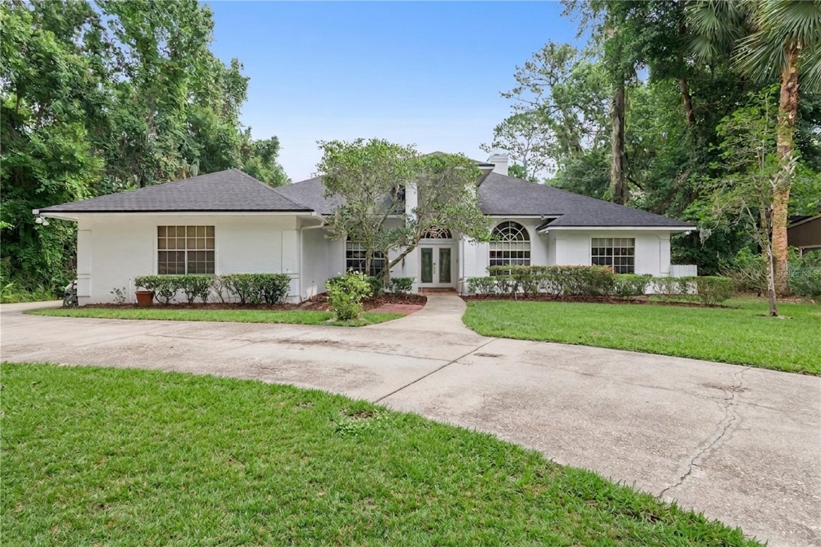 One or more photo(s) has been virtually staged. Tucked away on a quiet cul-de-sac in desirable Longwood, this beautifully maintained pool home offers a private, tree-lined setting on almost a half-acre. Designed for both comfort and entertaining, the home features a screened-in pool and expansive outdoor living space—ideal for enjoying Florida’s year-round lifestyle.  Inside, a thoughtfully designed split floor plan showcases spacious living and dining areas, complemented by uniform flooring throughout. The heart of the home opens to an impressive Florida room filled with natural light  and double sliders, complete with custom built-ins, a wet bar, and a fireplace, creating an inviting space for gatherings The kitchen offers both casual and functional dining with an eat-in area and bar seating, along with a built-in oven and microwave. Architectural details such as pocket doors, solid wood doors and transom windows add character and timeless appeal. The generously sized primary suite provides a relaxing retreat with a large walk-in closet, while one of the secondary baths features a walk-in shower and convenient access for pool use.  Additional highlights include a new roof (2023), indoor laundry room with sink, newer washer and dryer, new plumbing (2023) New exterior doors and a spacious 3-car side-entry garage with extensive storage. A long driveway offers ample parking for guests.  With its blend of space, privacy, and refined features, this home presents a rare opportunity in a sought-after Longwood location. Minutes from Wekiva Springs State Park, walking trails, dining, shopping and access to top-rated Seminole County schools.