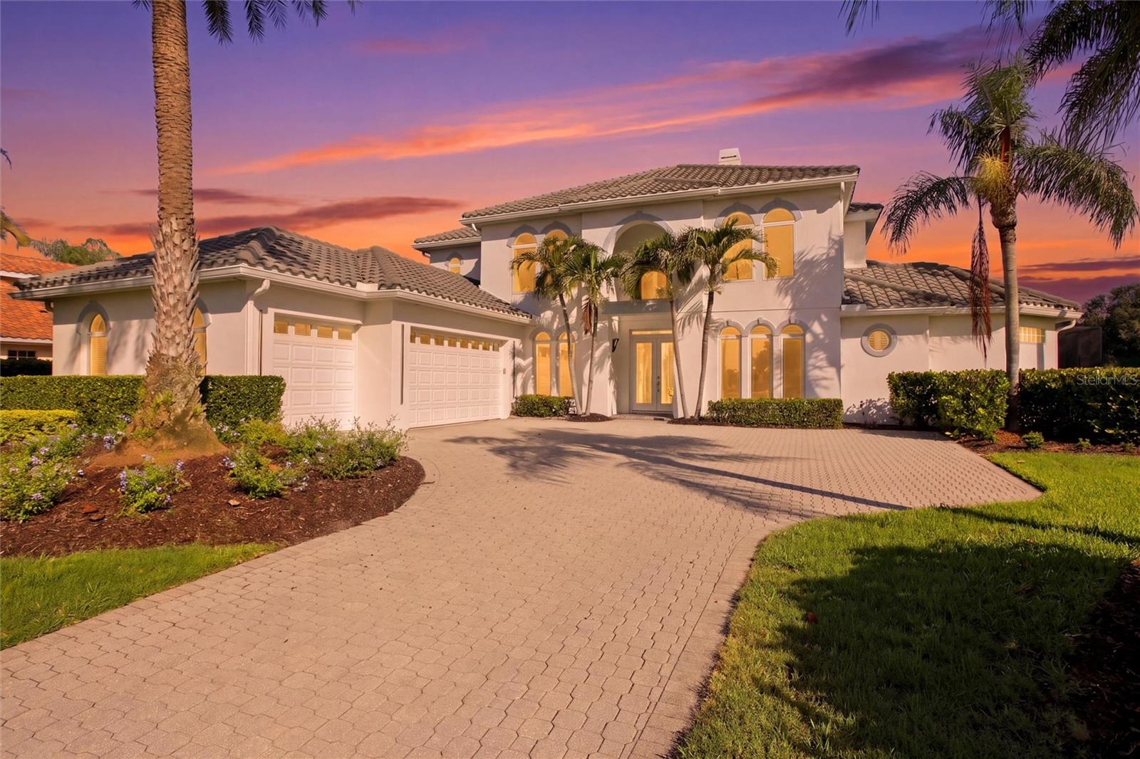 One or more photo(s) has been virtually staged. Located on a quiet cul-de-sac behind the gates of Misty Creek, this beautifully designed four-bedroom home offers stunning views of the 18th hole and lake from one of the community’s most desirable settings. A paver brick driveway and impressive curb appeal welcome you to this exceptional property. With the primary suite and private office on the first floor, and three additional bedrooms plus a large bonus room upstairs, the layout offers both comfort and flexibility. A grand entry with soaring cathedral ceilings opens to elegant living spaces featuring a fireplace with mantel, decorative built-in shelving, and sliding glass doors overlooking the lanai, pool, golf course, and water. Designed for entertaining, the kitchen features granite countertops, built-in double ovens, dual sinks, abundant cabinetry, a walk-in pantry, an expansive breakfast bar, and additional dining space — all overlooking the golf course and lake. Pocket sliding glass doors seamlessly extend the kitchen and living areas onto the expansive paver lanai, creating effortless indoor-outdoor living. The outdoor kitchen and bar, heated pool and spa, and pool bath make this home ideal for entertaining or relaxing in a private resort-style setting. A dumbwaiter provides convenient access from the kitchen to the upstairs bonus room. The spacious first-floor primary suite features private lanai access and a luxurious bath with a soaking tub, dual-head shower, separate vanities, water closet, linen closet, and dual walk-in closets with custom organizers. Upstairs includes a Jack-and-Jill suite with hardwood flooring, an additional bedroom, and a large bonus room complete with a wet bar, refrigerator, abundant cabinetry, washer and dryer, storage closet with shelving, and sliding glass doors leading to a private balcony with sweeping views of the golf course, lake, and the natural beauty of Misty Creek, where deer and native birds are often seen from this peaceful vantage point. The versatile bonus room offers endless possibilities and would make an ideal in-law suite, playroom, home gym, media room, or private guest retreat. Designed with exceptional storage throughout, the home offers large closets, custom built-ins, a walk-in pantry, and additional storage areas. The spacious first-floor laundry room includes abundant cabinetry, folding counter space, and a stand-up deep freezer. Additional features include a spacious side-load 3-car garage with EV charging capability, a three-zone HVAC system for enhanced comfort and efficiency, and a newer tile roof.