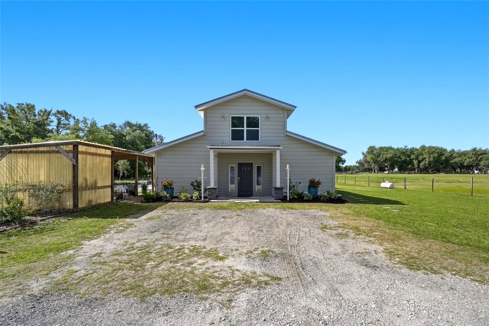 Situated on 6.57 fully fenced acres, this 2,576 square foot, 4 bedroom, 2.5 bath Barndominium style home offers the perfect blend of residential comfort and equestrian functionality. Zoned with an agricultural exemption and located in an X flood zone, the property includes a 1,700+ square foot six stall barn with electrical and water service, plus an additional tack shed. The gated driveway allows for fully secure boundaries, and with no HOA or pet restrictions, the possibilities here are endless.  The home features a durable metal roof, updated windows, and a thoughtfully designed layout that provides both flexibility and income potential. Inside, the open concept living areas are filled with natural light and showcase polished concrete floors, recessed lighting, and a seamless flow between kitchen, dining, and gathering spaces. The updated kitchen features stainless steel appliances, stone backsplash, expansive countertops, and abundant cabinetry, creating a modern yet inviting atmosphere.  The primary suite is located on the main level, offering privacy and convenience. You'll find a second bedroom, easily used as an office or den, and a half bath downstairs as well.  Upstairs can be completely closed off and functions as its own private living quarters with a kitchenette, living room, two full bedrooms, and a full bath. This configuration has previously been used successfully as an Airbnb, making it ideal for multigenerational living, guest accommodations, or continued short term rental income.  A generously sized laundry room provides excellent storage and everyday functionality.  Outside, the six-stall barn has previously supported a successful boarding operation and offers over 1,700 square feet of space with water and electric already in place. The acreage provides room for riding, grazing, or expansion while maintaining privacy from neighboring properties.  Located less than five miles from I4, commuting or traveling with horses is convenient and efficient. Conveniently located just minutes from Plant City amenities, with easy access to Lakeland Linder Airport, Tampa International Airport, nearby hospitals, and multiple equestrian trail systems including Sydney Dover and Green Swamp.  This property presents a unique opportunity for those seeking a private family estate, an income producing setup, or a fully functional equestrian property in a highly accessible location.