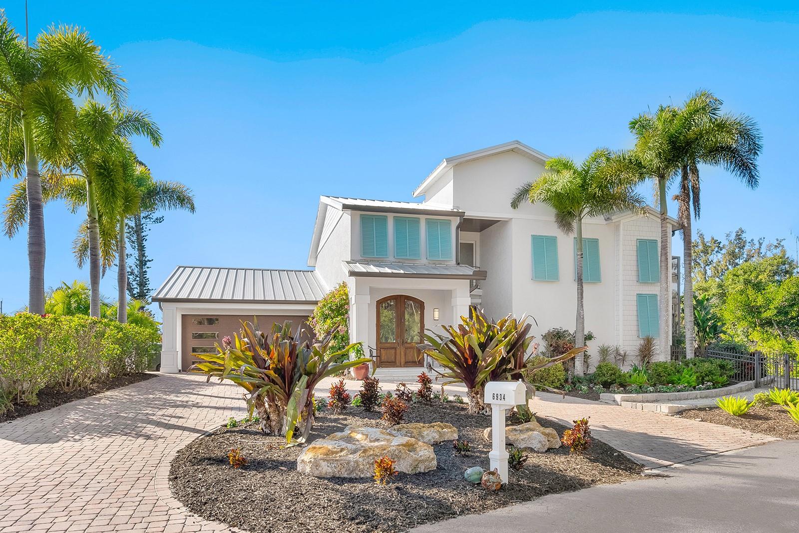 New price! Beautifully private, this exceptional Siesta Key residence delivers the lifestyle discerning island buyers seek. Ideally near the aqua Gulf waters and powdery white sands of Crescent Beach, and moments from the peaceful shoreline of Turtle Beach, this remarkable coastal retreat spans approximately 230 feet of protected boating water and is tucked at the end of a quiet, tree-lined street, offering rare privacy and a sense of peaceful seclusion seldom found on the island. This two-story home offers flexible living with three to four bedrooms, six and a half baths, an office or den, and thoughtfully designed indoor-outdoor areas that define relaxed island luxury. A gracious arrival sets the tone as antique wood-and-glass double-entry doors open to a light-filled foyer and formal living room, anchored by a custom electric fireplace and framed by soaring windows. Natural light pours in, highlighting architectural details and creating an immediate sense of warmth and understated sophistication. The heart of the home is a magnificent kitchen designed for entertaining and everyday living, featuring a generous central island that flows seamlessly into the inviting family room with a wood-burning fireplace. Walls of glass throughout dissolve the boundary between indoors and out, creating a seamless connection to the lush, private surroundings. The main level includes a private guest en-suite with direct lanai access, along with a unique screened atrium, an inviting space for alfresco dining, sunning, or quiet relaxation. An adjacent flex room easily serves as an office, studio, or additional guest suite, offering versatility for today’s evolving lifestyles. Upstairs, a graceful, curved staircase leads to another en-suite bedroom, a full bath adjacent to the office or flex space, and an owner’s retreat. The primary suite is a sanctuary, complete with separate spa-inspired baths, expansive walk-in closets, and a private sunset terrace overlooking the pool and tranquil canal waters, an ideal setting to unwind at the end of the day. Outdoors, the property transforms into a private waterfront oasis. The lushly landscaped pool area features cascading fountains, while boating enthusiasts will appreciate 230 feet of seawall, a private dock, a 7,000-pound boatlift, a kayak lift, and a separate fishing pier, all on deep, protected water with quick access to Sarasota Bay and the Intracoastal Waterway. Notably, the property experienced no damage or flooding during the 2024 storms, according to the owners, offering valuable peace of mind alongside its exceptional setting. Enjoy effortless access to the beach, nearby restaurants and shops, and free island trolley. When you’re ready to venture beyond the island, downtown Sarasota is just minutes away over the south bridge, offering world-class dining, arts and culture, including The Ringling, Van Wezel Performing Arts Hall, St. Armands Circle, and the vibrant Sarasota Farmers Market. This is a rare opportunity to own a storm-resilient waterfront retreat that seamlessly blends privacy, boating access, accessibility, and timeless coastal elegance, the best of Siesta Key living.