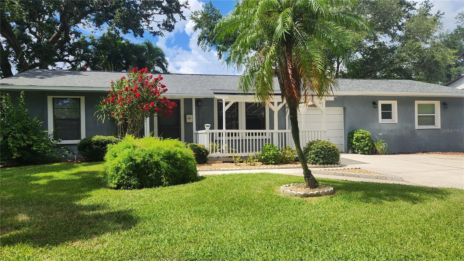 Welcome to this beautifully maintained home with mature landscaping on a peaceful tree lined street with no HOA’s. This home offers 3 bedrooms and 3 bathrooms. 1 bedroom and bath are in an attached private space, with its own entrance. This space could be used as a mother-in-law suite, private guest space or ADU. This home is situated on a double lot with an inground sprinkler system and spacious shed with electricity. You will enjoy having avocados and guavas from the mature trees on this property. The covered porch at the entrance of the home welcomes you with a beautiful relaxing pond and plentiful area for seating. The main living space includes vaulted ceilings, hardwood floors, granite countertops, modern ceiling fans, a spacious family room with a wood burning fireplace. Also included in this space is a pantry, indoor laundry with several cabinets for lots of storage. Step outside through the French doors (with enclosed blinds) to your private screened oasis.  A 26 x 12 foot inground pool offers the perfect relaxing environment for morning coffee, weekend gatherings or quiet evenings at home. This home has never flooded nor received structural damage from any storms including the storms of 2024. Another wonderful feature of this house is its location. Located minutes from vibrant downtown St. Petersburg, easy access to both the Gandy and I-275 and less than 30 minutes to gorgeous Gulf beaches. This house is an excellent opportunity for homeowners and investors seeking strong rental potential. This well-loved home features a history of just two owners.  As the third owner, what memories will you create here?