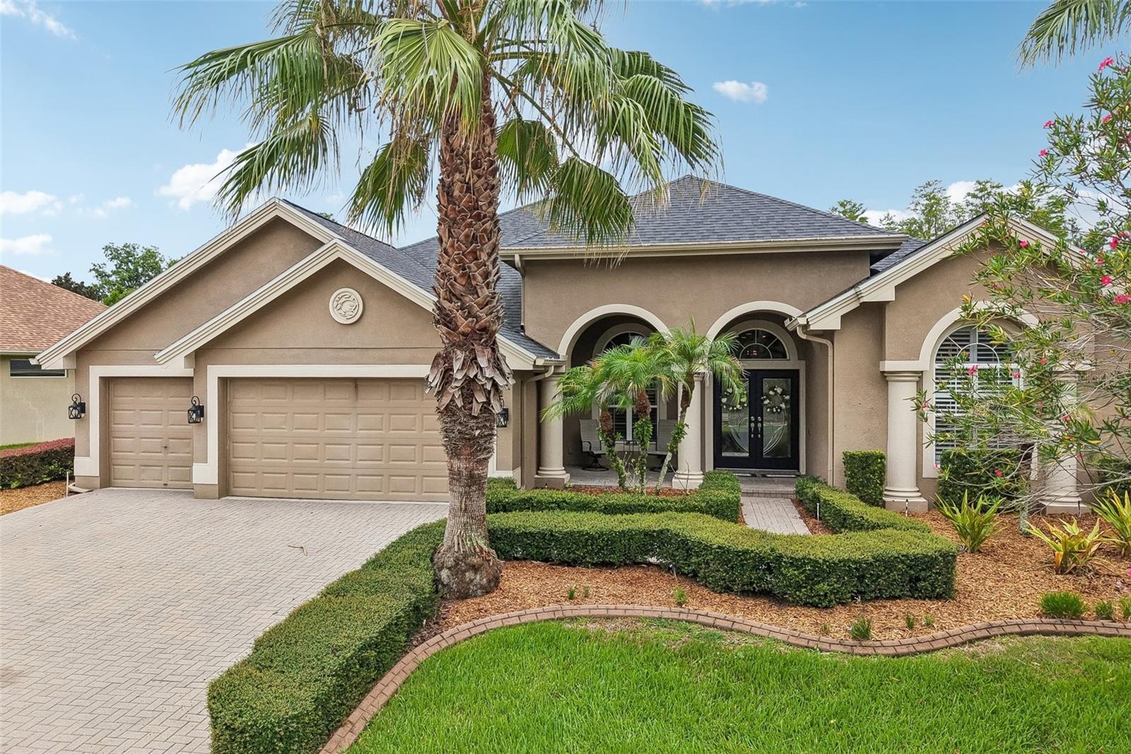 Tucked behind the gates of Plantation Palms on a private conservation homesite, this exceptional 5-bedroom, 4-bath residence offers the perfect blend of luxury, space, and Florida outdoor living. From the moment you arrive, the paver driveway, three-car garage, manicured landscaping with stamped concrete edging, and impressive double leaded-glass front doors create an unforgettable first impression.
Inside, fresh neutral interior paint, soaring ceilings, elegant crown molding, tray ceilings, plantation shutters, and timeless architectural details—including columns, arched doorways, and arched windows—combine to create a home that feels both grand and inviting. Natural light pours through the home, highlighting the spacious formal living and dining rooms, while a dedicated office or flex space with a striking accent wall provides the perfect work-from-home setup or bonus living area. A built-in speaker system, upgraded lighting and ceiling fans, and plenty of recessed lighting add comfort and sophistication throughout.
Designed with entertaining in mind, the heart of the home is the expansive kitchen featuring crisp white cabinetry with crown molding, an oversized center island with seating, a breakfast bar overlooking the family room, a built-in desk area, customized pantry organization, and a wine refrigerator. Whether hosting family gatherings or casual evenings at home, this open-concept space is built to bring everyone together.
The luxurious primary suite is a true retreat, offering private sliding glass doors to the lanai, dual walk-in closets, and a spa-inspired en suite bath complete with dual vanities, a dedicated makeup area, and an oversized walk-in shower featuring designer tile and a frameless glass enclosure.
Upstairs, a massive bonus room with brand-new carpet provides incredible flexibility as a fifth bedroom, guest suite, media room, or game room, giving everyone plenty of space to spread out.
Step outside and discover your own private backyard paradise. The beautiful paver lanai overlooks a heated saltwater pool with elegant fountains and a self-cleaning system, all set against peaceful conservation views with no rear neighbors. An outdoor kitchen makes entertaining effortless, creating the ultimate setting for weekend barbecues, sunset dinners, or simply relaxing in your own private oasis.
With a 2021 roof, an ideal floor plan, premium upgrades throughout, and an unbeatable location within the gated Plantation Palms community, this home offers the lifestyle you've been waiting for. Luxury, privacy, and exceptional indoor-outdoor living come together in one remarkable property.
