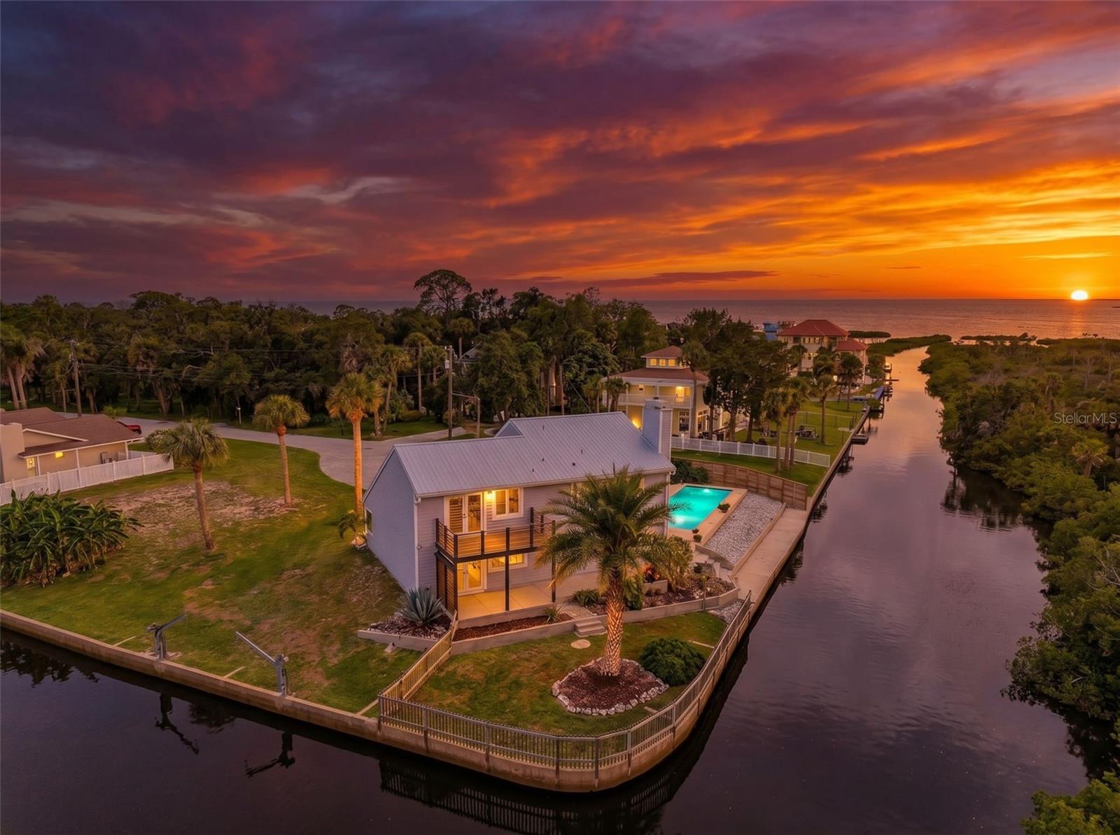 This must-see, one-of-a-kind waterfront pool home tastefully blends coastal-cottage features with creature comforts rivaling the newest construction. Located at the end of a very private cul-de-sac, this beautiful residence has canal frontage on two sides. Also, included is the waterfront lot adjacent to the south of the home. The canal frontage totals 327 feet! The two properties comprise .41 acres – you would own nearly the entire cul-de-sac - keep both or sell the 2nd lot. BRAND NEW in 2026: AC system with 10-yr warranty, wood-look porcelain tile floors throughout the first floor; sparkling clean, large country kitchen with white, shaker style cabinets, quartz counters, & strategic spot-lighting; interior doors & hardware, crown molding, wood trim, swimming pool pump, clothes dryer; entire 1st floor bath - vanity, cultured marble counter, fixtures, shower & toilet; fresh interior paint throughout. NEW 2023 to 2025: all kitchen appliances, exterior paint, dbl pane impact windows in living room and baths, 3 dbl pane impact French doors, plantation shutters; interior electric switches & outlets updated to code, water heater main circuit panel wired for generator (2023 portable generator included); 2nd floor bath – vanity plumbing updated; cypress wood privacy fence, exterior lighting. The original cedar siding & trim was replaced with Hardie Board in 2008. Complete list of recent improvements available upon request. The boat ride to the open waters of the Gulf of America is a ½ mile straight shot out the main canal behind the home. Enjoy the beautiful mangroves and watch for manatees! The privacy and beautiful views are wonderful! The oversize swimming pool measures a tremendous 40’x12’ - play pool design: 4’ depth at each end and 5’ at the center. The master bedroom with wood burning FIREPLACE is on the first floor with views through the French doors of tropical plantings and the main canal. There’s also a wood-burning FIREPLACE in the living room where the vaulted ceiling soars to 17 feet! Up the stairs (behind the chalkboard wall) is where the country-cottage vibe really kicks in. The stairs open to a huge 21’x14’ loft which overlooks the living room. The flooring on the entire 2nd floor is hardwood  (tile in the bathroom). One bedroom is a generous 14’x12’ and the other is 17’x13’ – that’s a huge room with two built in beds  (see photos) perfect room for sharing by siblings - plenty of room for other furniture. More than ample storage is another fantastic feature of this unique home. The large upstairs bedroom has a “regular” closet which measures 10’x3.5’ AND a 2nd closet which is 21’ long with built-in shelves! The master bedroom also has a large walk-in with built-in shelves, and there is a large, lighted closet under the stairs.