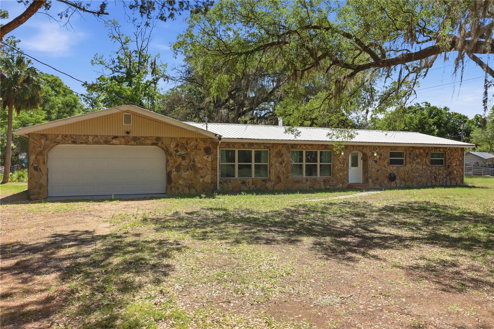 Step into a truly unique, beautifully remodeled home that blends timeless character with modern comfort, your perfect private country retreat. Set on over an acre of land, this property offers peace, privacy, and a true countryside feel from the moment you arrive.
Inside, a stunning stone wall and fireplace create a warm, inviting focal point, while sleek ceramic tile flooring flows throughout the main living areas for a clean, contemporary look. Double pane windows fill the home with natural light, enhancing the bright and airy atmosphere. The property includes a metal roof, providing enhanced durability and peace of mind.
The fully updated kitchen features crisp white cabinetry, stainless steel appliances, and elegant stone countertops. Just off the main living area, A spacious flex room provides the perfect opportunity to create a home office, fitness area, game room, or studio tailored to your lifestyle; enhanced by sliding glass doors that lead directly to the backyard for effortless indoor-outdoor living.
This spacious home includes 3 bedrooms and 3 full bathrooms. The primary suite features its own private en-suite bathroom, while the two additional bedrooms share a full hall bath. A third bathroom with a shower is conveniently located near the kitchen ideal for guests.
Enjoy the practicality of a laundry area located in the garage, along with ample storage space. 
Step outside to a peaceful backyard oasis, complete with a spacious patio deck perfect for relaxing mornings, entertaining guests, or enjoying the natural surroundings. The expansive yard provides plenty of room for outdoor activities, gardening, or simply unwinding in your own private retreat.
Whether you're a first-time homebuyer, an investor, or exploring Airbnb potential, this property offers flexibility, value, and opportunity.
With no HOA, No CCD. Located in Flood Zone X, this property offers added peace of mind with a lower risk of flooding. This designation typically means flood insurance is not required by lenders, helping reduce overall ownership costs while providing greater confidence in your investment.
A rare blend of charm, space, and modern updates, this move in ready home is your secluded slice of paradise. This stunning home is truly a must-see!