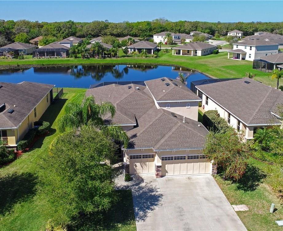 Beautifully updated lakefront pool home in sought-after Greyhawk Landing offering 4 bedrooms plus an office, bonus room, and possible 5th bedroom, with 3.5 baths and a 3-car garage. Positioned on a premium waterfront lot, this home showcases peaceful lake views from the screened paver lanai and private pool with a 7-foot deep end. Inside, a spacious foyer opens to a formal dining room with tray ceiling and a dedicated office with French doors. The fully equipped kitchen is designed for both everyday living and entertaining, featuring stainless steel appliances, granite countertops, tile backsplash, LED lighting, upgraded cabinetry with crown molding, abundant prep space, and an electric range already connected for gas if desired. The great room offers generous living space with direct views of the lanai and pool area. The primary suite features a tray ceiling, custom walk-in closet built-ins, and a spacious bath with dual vanities, upgraded tile, and a relaxing garden tub. Four bedrooms and two full baths are located on the main floor, while upstairs includes a large bonus room with closet space that can easily function as a 5th bedroom, media room, or guest retreat. Additional upgrades include newer flooring throughout, an upgraded laundry room with cabinetry and granite counters, designer lighting and fans, gutters, and a newer AC system. Residents of Greyhawk Landing enjoy resort-style amenities including two community pools, a fitness center, tennis and basketball courts, a fishing pier, clubhouse, baseball and soccer fields, volleyball courts, miles of walking and biking trails, plus a splash park with a water slide, mushroom fountain, and lap lanes. Rarely does a home combine this level of space, upgrades, views, and community amenities in one package. Some images in this listing have been virtually staged
