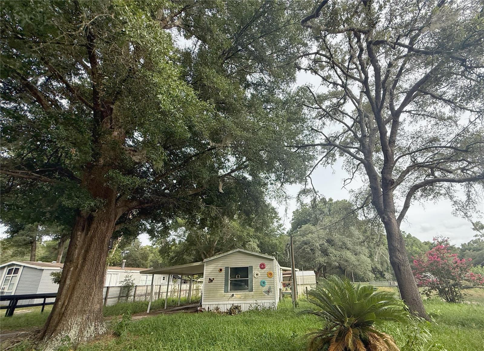 This diamond in the rough is in the sweetspot of Dunnellon with easy access to the famous Nature Coast's serene beauty and near the modern ammenities of Ocala. The home will need a new owner to bring back the charm of this cottage-like home. There is a half bath in the primary bedroom for a bonus private space from the guest room and guest bath area. The kitchen has bar seating available and has the perfect picture window over the sink. The guest bath includes a combination bathtub shower and vanity. The washer and dryer hookup is tucked away in a nook that leads to the back door and small deck area. There is an attached carport to have covered parking that leads to the front door. There are mutliple sheds for storage and a fully fenced back yard. Seize the oppurtunity of this home to make it your own cozy cottage to access the full Florida lifestyle at budget price.