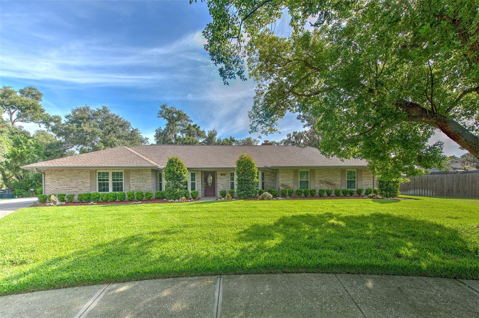 CUSTOM BUILT | ORIGINAL OWNER | PRIVATE HALF-ACRE RETREAT | A HOME THAT FEELS LIKE HOME ~ Some homes check boxes. This one creates a feeling.  Custom built by John Henderson and lovingly maintained by its original owner, this exceptional residence offers timeless design, quality craftsmanship, and the kind of setting that rarely becomes available.  Perfectly positioned on a beautifully manicured half-acre homesite, every arrival feels special. Inside, rich hardwood flooring flows throughout the living spaces, creating warmth and continuity. Generous room sizes, classic architecture, and exceptional care are evident at every turn.  The dream kitchen was designed for gathering and everyday enjoyment—featuring granite countertops, warm wood cabinetry, tumbled stone backsplash, stainless steel appliances, and abundant workspace. Beautiful bay windows fill the breakfast nook with natural light while offering tranquil views of the surrounding landscape.  Entertain with ease in the formal dining room, enjoy quiet moments in the formal living room, or retreat to the separate study—perfect for working from home, reading, or creating your own private escape. The owner’s suite is thoughtfully designed with comfort and convenience in mind, featuring a spacious bath with dual granite vanities, soaking tub, separate shower, and a private valet area with built-in cabinetry leading directly into the laundry room.  Secondary bedrooms are generously sized, and the secondary bath offers dual sinks to comfortably accommodate family and guests.  Step outside and discover the true showpiece of this home…a large screened lanai overlooking your private backyard oasis—an incredible place to enjoy morning coffee, entertain guests, watch the birds, or unwind at sunset surrounded by beautiful landscaping and peaceful fountain views.  An added bonus: the original garage has been transformed into an incredible workshop and flex space for hobbies, projects, and an inside study, home office, or additional living area. Buyers desiring traditional garage parking will appreciate the flexibility to potentially convert the space back to a spacious 2-car garage.  Homes with this level of care, character, privacy, and flexibility are increasingly difficult to find.  This isn’t just a place to live—it’s a place to slow down, gather, and enjoy life.  Sellers have done all the major improvements ~ A/C 2017, new windows 2020, new roof 2023, trim lights around exterior of home, and completely fenced yard for privacy!