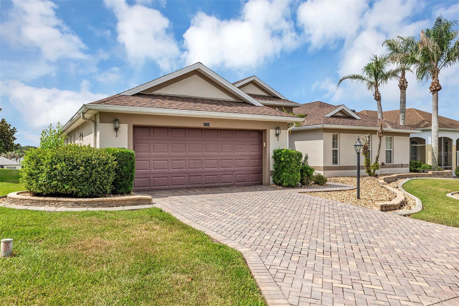 Welcome to this beautifully maintained and extensively upgraded home located in one of the area's most sought-after active adult communities. Elegant, spacious, and truly move-in ready, this exceptional residence offers over 2,500 square feet of thoughtfully designed living space with stunning golf course views. From the moment you arrive, you'll appreciate the pride of ownership and attention to detail throughout. Recent upgrades include a new roof (2022), granite countertops in the kitchen and bathrooms, premium Bosch and GE Profile appliances, updated lighting and plumbing fixtures, interior and exterior paint, crown molding, and gorgeous Brazilian cherry wood flooring complemented by ceramic tile throughout the home. Step through the impressive foyer featuring marble flooring and an elegant chandelier, and you'll immediately be drawn to the expansive living room with vaulted ceilings, floor-to-ceiling sliding glass doors, custom window treatments, and breathtaking views of the 12th fairway. The oversized 28' x 12' enclosed lanai provides the perfect place to relax, entertain, and enjoy the beautiful golf course setting year-round. The thoughtfully designed floor plan includes two spacious en-suite primary bedrooms, each featuring large walk-in closets. The main primary suite offers a luxurious bath with dual vanities, a soaking tub, and a large walk-in shower. A comfortable den just off the foyer provides the ideal space for a 3rd bedroom, home office, library, or hobby room. The formal dining area is perfect for entertaining and features crown molding, custom window treatments, and a built-in wet bar. A convenient half bath is located nearby for guests. The spacious kitchen offers abundant cabinetry, a double pantry, a center island with seating, and room for a breakfast table. Adjacent to the kitchen, the inviting family room provides additional living space and beautiful golf course views. With numerous upgrades, impeccable maintenance, elegant finishes, and a premier location within a highly desirable active community, this exceptional home is a rare opportunity that must be seen to be fully appreciated.