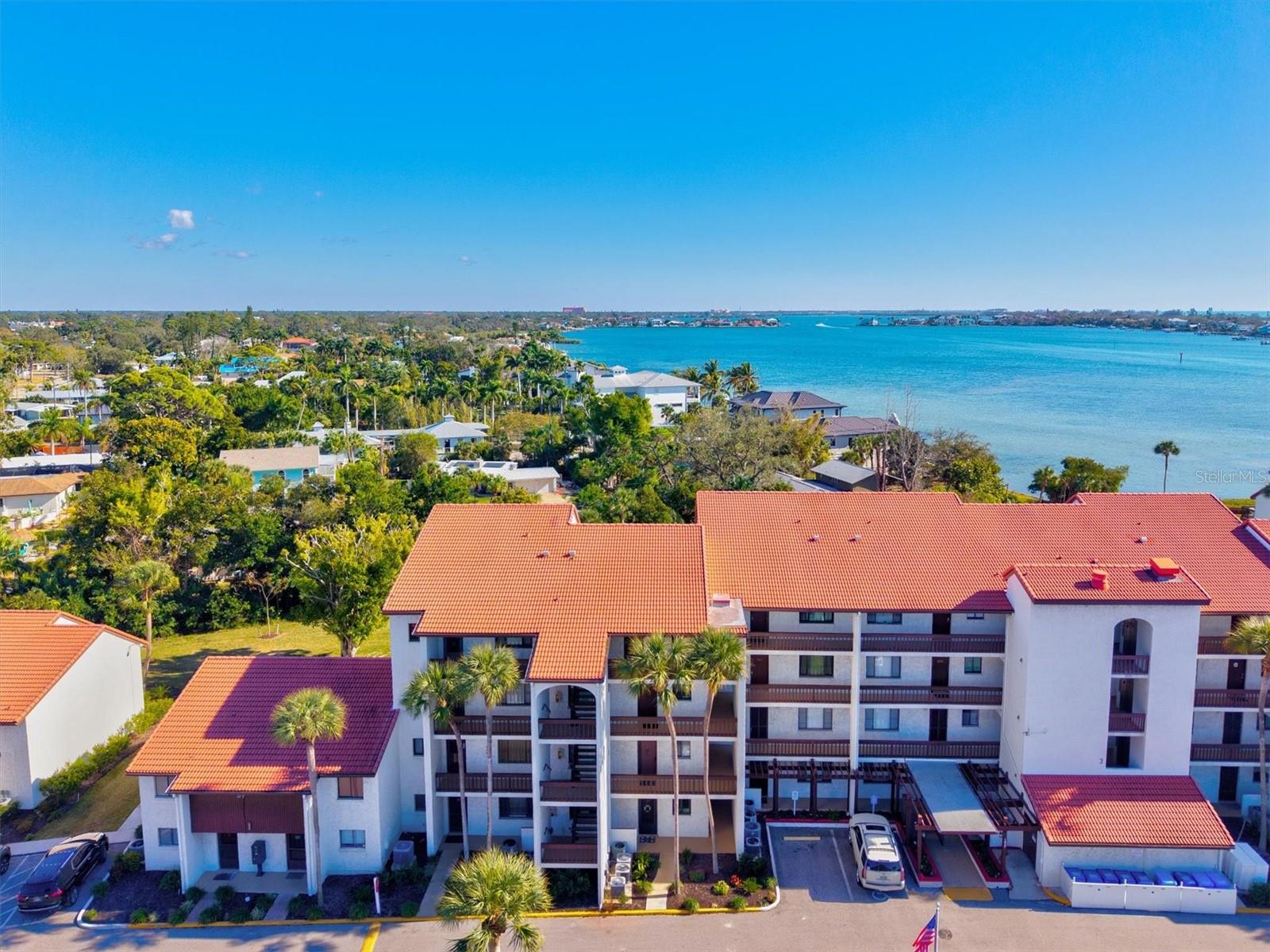 Take in the stunning Intracoastal Waterway views from your rare, oversized private terrace, a feature enjoyed by only a select few units in the complex. Here at Castel Del Mare, you’ll find one of Sarasota’s most desirable waterfront communities located at the gateway to Siesta Key Beach. This beautifully updated 1 bedroom, 1 bathroom top floor condo sits on the fourth floor with views of the Intracoastal Waterway and Sarasota Bay that create an instant sense of coastal living from the moment you enter. All windows and sliding doors are hurricane impact, offering peace of mind as well as added sound and energy efficiency. Arriving by elevator, the condo immediately feels warm and welcoming. The kitchen features modern espresso cabinetry with generous storage, granite countertops, a stylish backsplash, stainless steel appliances, and a breakfast bar with plenty of seating. Vaulted ceilings and crown molding make the space feel open and airy. The bedroom includes sliding glass doors to the terrace, a custom closet system, and direct access to the updated bathroom. The bathroom features modern finishes, an upgraded vanity, and a glass enclosed shower with floor to ceiling tilework and a rainhead shower. The home also includes a tankless water heater and an assigned parking space for added convenience. The spacious terrace is the perfect place to relax with friends and family, complete with a bartop overlooking the tennis courts and tranquil water views beyond. Castel Del Mare offers a true resort style lifestyle with amenities that include two heated swimming pools, one overlooking the bay, tennis courts with pickleball lines, a bayside fishing pier, kayak storage, shuffleboard, BBQ areas, a clubhouse, and a scenic waterfront boardwalk along the water. Maintenance free living includes cable TV, escrow reserves, insurance, exterior and grounds maintenance, on site management, pest control, pool care, private road maintenance, sewer, trash, and water so you can enjoy more of the coastal lifestyle without the worry. The sugar white sands of Siesta Key Beach are only a short walk away along with marinas, boat rentals, waterfront dining, shopping, and entertainment. Ideally located on the mainland, this community provides convenient access to all that Sarasota has to offer while maintaining the charm of peaceful waterfront living. Whether you are searching for a full time residence or a seasonal retreat, this bayfront condo offers the Florida lifestyle at its finest. Schedule your showing today.