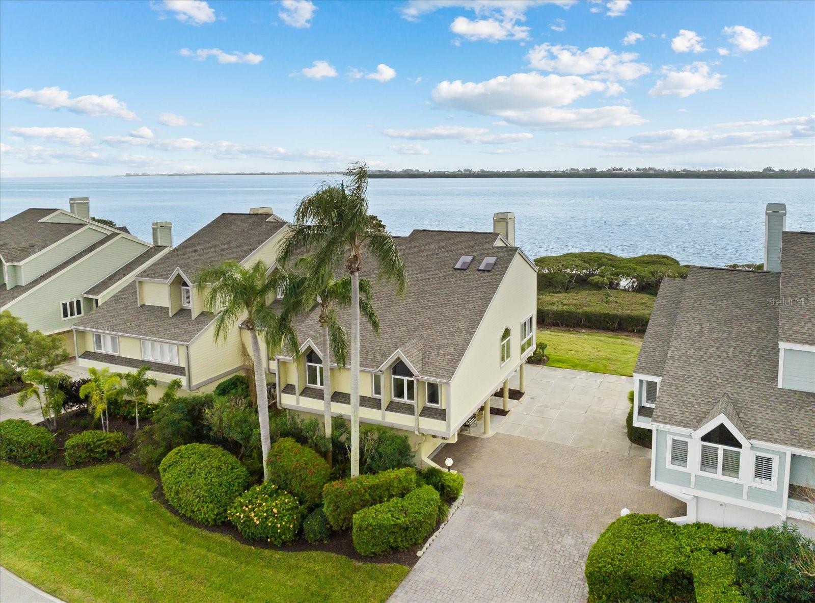 From $1,245,000 to $846,000 — the seller has made a bold repositioning to get this beautifully renovated unit SOLD now!  

Presenting one of the newest and most up-to-date transformations on Tidy Island, an exclusive, gated private island that feels worlds away yet remains just minutes from everyday conveniences. This unique low-density enclave of stately waterside residences is celebrated for its manicured grounds and preserved natural setting, with nearly 85% of the island’s 240 acres protected as wildlife sanctuary. This beautifully renovated end-unit residence underwent an exacting redesign, including a new kitchen, primary and guest bathrooms, flooring, fixtures, improved layout, and accessibility enhancements. 

Inspired by a light coastal New England design, the home offers a flexible, open floorplan that captures sweeping Sarasota Bay views and fills the interiors with ever-changing natural light. Stepping inside reveals a sophisticated departure from the standard Florida condo, with a dramatic dining area highlighted by soaring ceilings and skylights, and a living room anchored by the newly rebuilt wood-burning fireplace, custom built-ins, and panoramic water vistas. A sunroom-like space with floor-to-ceiling windows provides the perfect perch for reading, creative pursuits, or simply enjoying the tranquil surroundings. The adjoining lanai, finished in tile, offers both covered and open-air enjoyment. The thoughtfully redesigned kitchen features new cabinetry, granite countertops, KitchenAid appliances, a two-zone beverage cooler, table-height seating, and abundant, cleverly planned storage. A guest bedroom, full bath, and utility area complete the main level.

Upstairs, the primary suite enjoys full bay views and a refreshed, breezy ambiance. The renovated en suite bath includes a zero-entry glass shower, dual-sink vanity with LED lighted mirrors, Toto commode, accent lighting, and generous closet space. A lofted creative or office nook sits opposite the primary bedroom, adding further flexibility and added sleeping quarters for guest overflow. A private THREE STOP ELEVATOR and mobility-friendly features throughout allow for effortless living and graceful aging in place.

The ground level offers a two-car garage with the newly installed garage door and an additional storage room or workshop. 
Tidy Island continues to enhance its already exceptional lifestyle offerings, now featuring new PICKLEBALL courts and refreshed fitness and meeting spaces alongside its established amenities. The all-inclusive fee covers two pools, tennis courts, a clubhouse, an archaeology museum chronicling island history dating back to 500 B.C., nature trails and boardwalks, a kayak launch with rinse station, 24-hour staffed gate security, onsite maintenance and property management, shoreline and roadway care, exterior building maintenance, pest control, cable, Wi-Fi, water, trash, and more.

Tranquil, secure, and private, this end-unit residence is MOVE- IN READY and ideal as a seasonal retreat, second home, or a perfect reason to embrace Florida living full-time. With unmatched serenity, abundant wildlife, scenic walking and biking paths, and a vibrant sense of community, you’ll quickly fall in love with the Tidy Island lifestyle. An extensive list of upgrades and features is available upon request