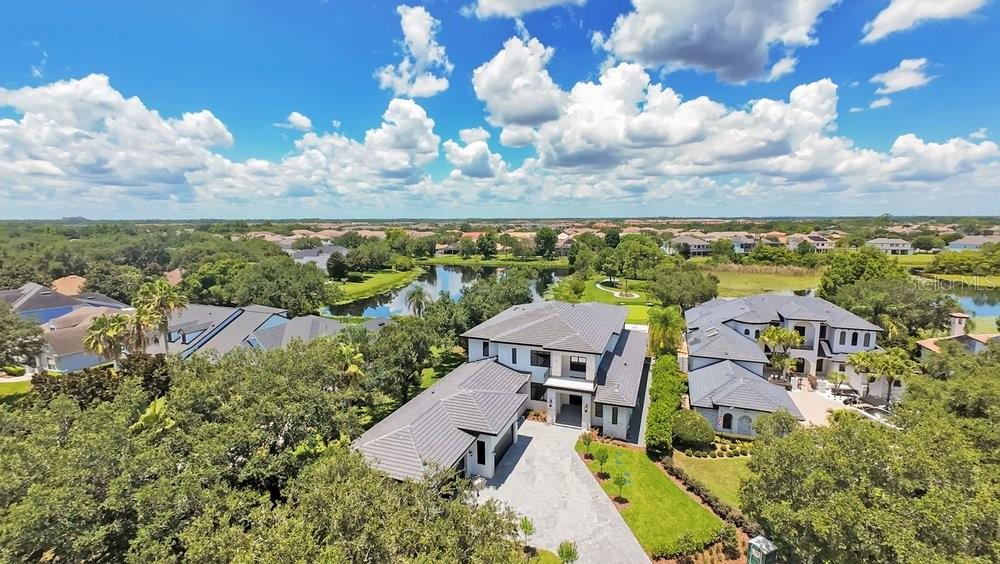 Virtually Staged. Welcome to an extraordinary new construction waterfront estate built by Element Home Builders, located in the prestigious 24-hour guard gated community of Keene’s Pointe. Situated on a private cul-de-sac, this one of a kind residence rests on a spectacular 0.78 acre homesite with 518 feet of combined waterfront overlooking a serene pond and the beautiful waters of Lake Burden. Offering 8,133 square feet under air and 10,971 total square feet, this exceptional home features 8 bedrooms, 7 full bathrooms, and 3 half bathrooms with unparalleled craftsmanship and luxury finishes throughout. A grand marble foyer welcomes you with soaring ceilings, designer lighting, wood beams, and rich solid oak flooring. The stunning chef’s kitchen features custom solid wood cabinetry, stunning countertops, Thermador paneled refrigerator and freezer with white wine refrigeration, Wolf range, built-in convection oven, microwave, and a custom exhaust hood. The expansive great room showcases a natural stone fireplace and wall to wall sliders that open to breathtaking views of the infinity edge saltwater pool, spa, backyard oasis, and Lake Burden. The luxurious primary suite offers panoramic water views, custom illuminated walk-in closets, a spa inspired bathroom with a massive shower, designer fixtures, and a freestanding soaking tub. Additional highlights include a temperature controlled wine cellar, hidden elevator, executive study with custom built-ins, five spacious main level bedrooms, and a spectacular second floor featuring a private gym with reinforced insulation, custom theater, loft with kitchenette, balcony overlooking the water, and three ensuite bedrooms. Outdoor living is designed for entertaining with your summer kitchen including a heavy duty grill and hood, motorized screens for the entire lanai, multiple gathering areas, fire pit, private putting green, and a nature path leading to your covered boat dock with boat lift for endless Lake Burden adventures on a 125 acre skiable lake. A four-car garage with built in ceiling lighting tracks and electric vehicle charging completes this exceptional residence. Keene’s Pointe offers an unmatched lifestyle with the Golden Bear Club, featuring a championship golf course, clubhouse, fitness center, tennis courts, resort-style pool, and numerous parks and recreation areas. Ideally located just minutes from Walt Disney World, world class dining, shopping, and top rated schools, with close proximity to Windermere Preparatory School. This rare never been lived in lakefront estate is being offered for the first time and represents a unique opportunity to own one of Central Florida’s finest custom homes. Be sure to click on the virtual tour links.