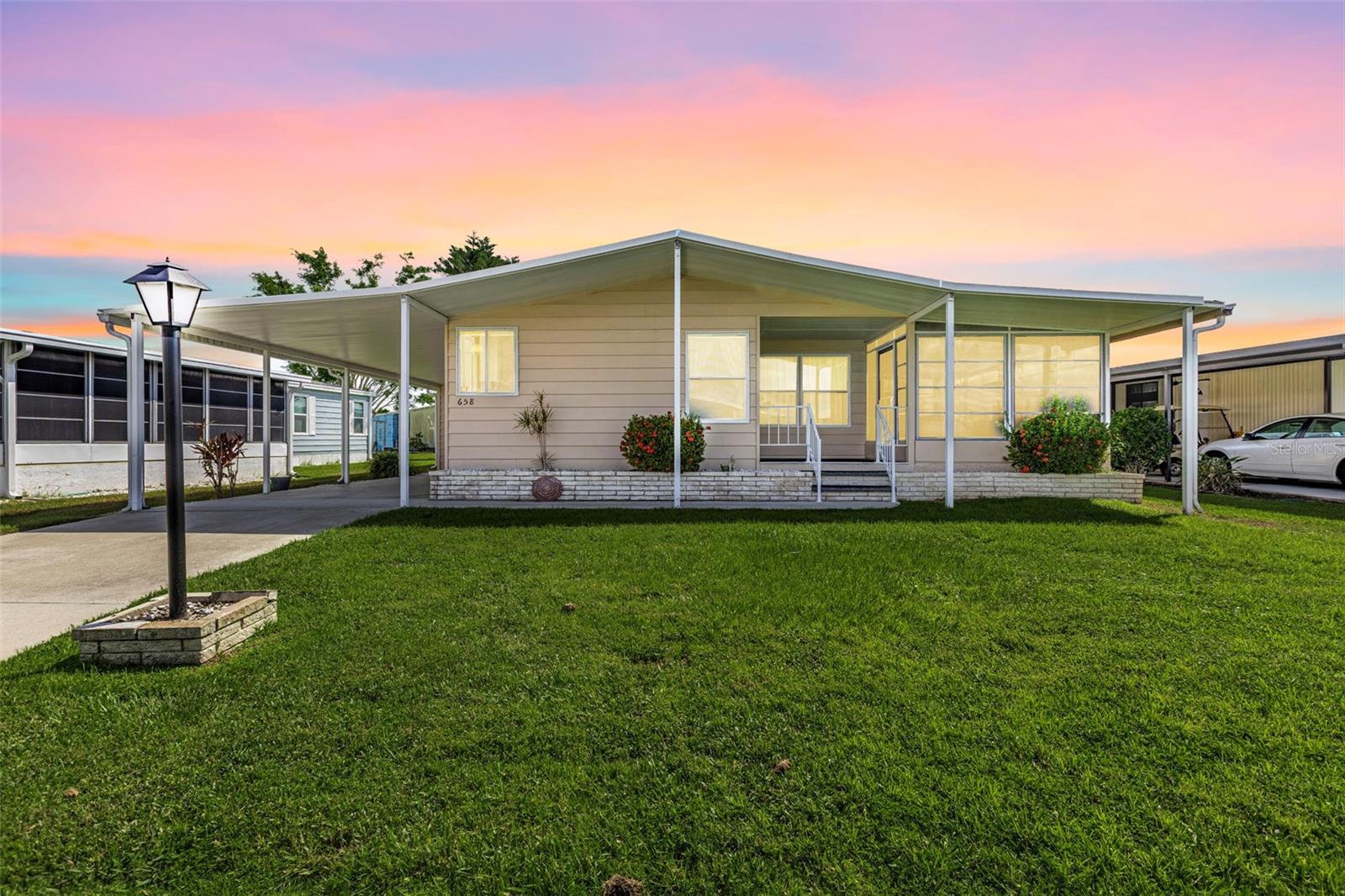 This lovely two-bedroom, two-bath home is situated on a quiet street in La Casa. The kitchen features an entryway with a built-in desk, a center island, newer cabinets, a storage cubby, and modern appliances. You can enjoy your morning coffee in the corner breakfast nook while taking in the street views. The dining room includes a built-in hutch, perfect for storing your China and special belongings. Sliding doors from the living room lead to a vinyl-enclosed Florida room, which also has a door to the covered front porch. The primary bedroom boasts a dressing area with a new vanity, a marble countertop, two medicine chests, and a spacious walk-in closet. The primary bathroom includes a walk-in shower. The guest bedroom features a mirrored pocket door that opens to a large walk-in closet, while the guest bathroom has a vanity and a tub/shower combination. The home  offers central A/C and ceiling fans, and a new Comfort Cover roof-over added in 2023. The extended carport leads to a utility room equipped with a workbench, storage, a washer, a dryer, and a deep sink.
La Casa boasts 974 homes nestled among a variety of native trees with spacious common grounds surrounding our eight lakes. Our lots average a generous 60' by 80'. La Casa, offering the ultimate lifestyle on Florida’s Gulf Coast, is located between Sarasota and Fort Myers. . It is convenient for shopping, sightseeing, golfing, fishing, and boating, as well as all the culture and elegance the Southwest Florida area is noted for. Residents and visitors enjoy the warmth of Southwest Florida winters in a relaxed and unhurried environment far removed from the hustle of Florida’s east coast. You’ll be surrounded by mature lush landscaping which demonstrates the utmost level of care our property receives from residents and management.  Wireless Internet (Wi-Fi) is available at the Clubhouse, Activity Building, and Recreation Hall area where the pools & spas are located, so you can catch some rays while you catch up on your email! Sound enticing? La Casa is a friendly, family community. You will be away from the hustle and bustle except when you want to be part of it. Come for a visit to this self-contained oasis and see for yourself why La Casa is the ultimate destination for both snowbirds and year-round residents!