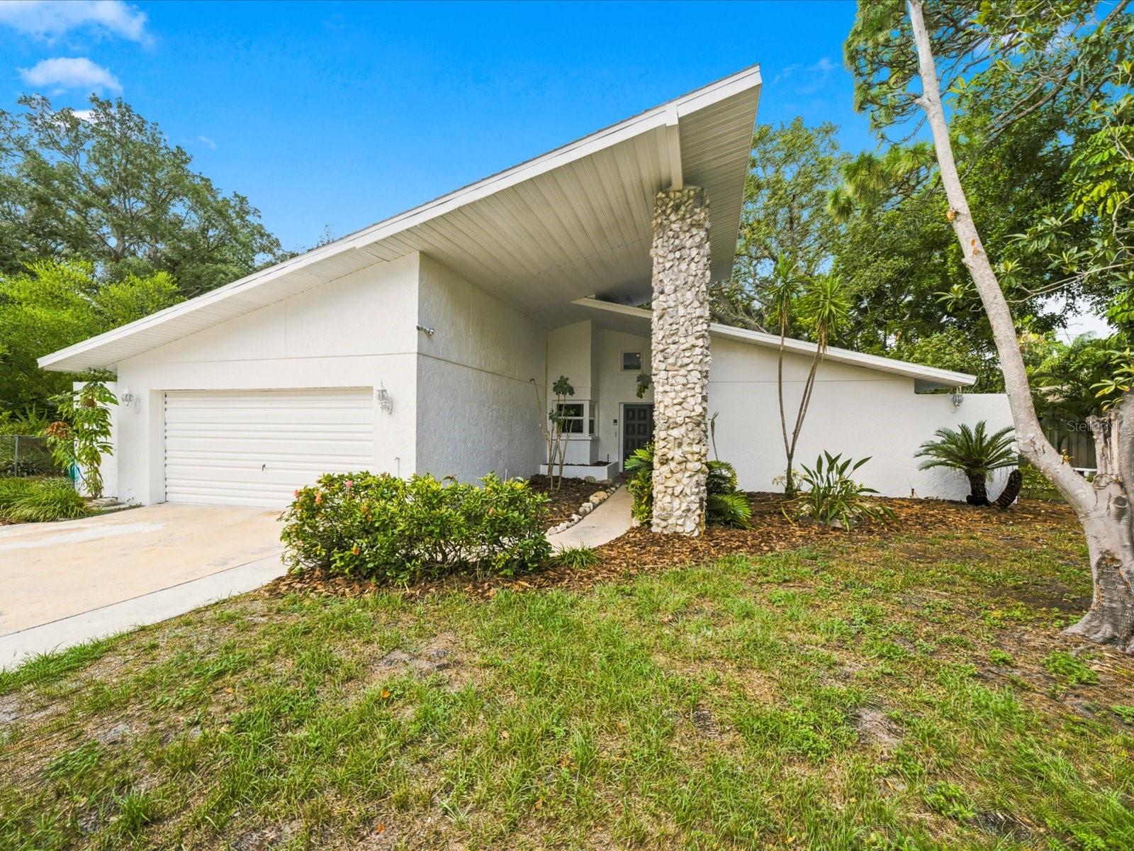 Welcome to 419 Wayfarer Court, where distinctive architecture, valuable recent improvements and an oversized homesite come together in a convenient Tarpon Springs location. Situated on approximately 0.36 acres in Flood Zone X, this 2-bedroom, 2-bath home offers approximately 1,784 square feet of living space, a two-car garage and a large fenced backyard surrounded by mature trees and tropical landscaping.

A covered entrance and double front doors open to a bright, spacious interior defined by soaring vaulted ceilings, clerestory windows and an abundance of natural light. The open floor plan connects the living room, dining area and kitchen, creating a comfortable setting for both everyday living and entertaining. Waterproof luxury vinyl flooring and recessed lighting were added in 2025, the interior was painted approximately one year ago, and the exterior received a fresh coat of paint in July 2026.

The kitchen offers extensive cabinetry, generous counter space, breakfast-bar seating and additional built-in storage. A new garbage disposal was installed in 2025. Both bedrooms are generously sized, while the primary suite features multiple windows, a walk-in closet and a private bathroom with dual vanities and a walk-in shower. Both toilets were replaced in 2025.

An enclosed Florida room provides flexible space for a home office, hobby room, reading room or additional sitting area, with direct access to the backyard through an Andersen retractable storm door installed in 2026. The interior laundry room includes cabinetry and a utility sink added in 2026.

Major improvements continue with a new roof completed in 2025 and storm-rated thermal windows installed in 2026. A fire-rated entry door between the residence and garage was also installed in 2026.

Outside, the oversized fenced backyard offers a private, wooded setting with a patio, storage shed and plenty of room for gardening, outdoor entertaining or creating a personalized backyard retreat. The home is located in Flood Zone X; buyers should independently verify current flood-zone information and insurance requirements.

Enjoy convenient access to Fred Howard Park and Beach, Sunset Beach, the historic Sponge Docks, Downtown Tarpon Springs, the Pinellas Trail, local marinas, shopping, dining and Gulf Coast recreation. With its dramatic architecture, flexible living space, substantial recent improvements and exceptionally spacious lot, this Tarpon Springs home offers character and possibilities that are difficult to duplicate.