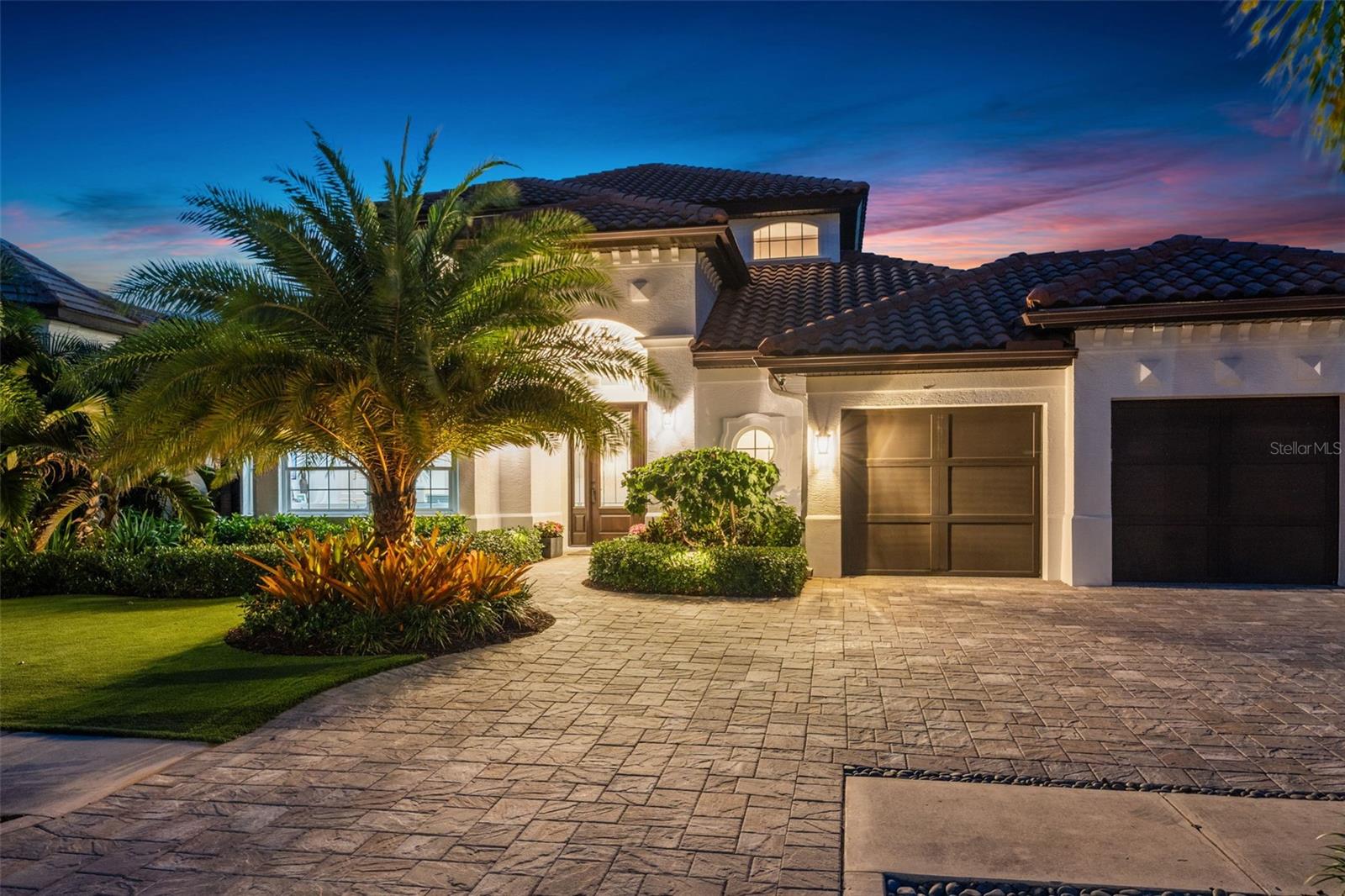 A timeless statement of modern luxury, this impeccably reimagined West of Trail residence exudes sophistication, serenity and refined coastal elegance. Completely remodeled, professionally designed and expertly curated, this extraordinary Sarasota home showcases one-of-a-kind craftsmanship, elevated design and exceptional finishes throughout, creating an unparalleled luxury living experience in one of Sarasota’s sought-after neighborhoods. Distinguished appointments include custom cabinetry by Das Holz Haus, reclaimed wood architectural elements, engineered luxury hardwood flooring, designer lighting with Lutron controls, rich designer paint finishes and bespoke décor. Encompassing 3,161 square feet heated and 4,194 total, this floor plan is designed for everyday living, entertaining and relaxing. At the heart of the home, the chef’s kitchen, anchored by two oversized islands, including a breakfast bar, and surrounded by artisan-crafted solid wood cabinetry. Brushed honey bronze fixtures and hardware complement Calcutta quartz countertops, while a farmhouse sink with a designer faucet enhances beauty and functionality. Culinary enthusiasts will appreciate the professional-grade appliance package highlighted by a 2021 La Cornue five-burner gas range with double convection ovens, custom chimney hood and premium ventilation system. Complimented by 2021 Sub-Zero refrigerator, 2021 Sub-Zero refrigerator drawers, 2021 Sharp microwave, 2021 Miele built-in coffee maker, 2025 Sub-Zero wine cooler, 2021 Scotsman ice maker, 2025 Galley sink tap, Shaw fireclay main sink, Shaw fireclay bar sink and Zip water system for bar (hot, cold, sparkling). The kitchen flows seamlessly into the dining area and living room, where a sleek linear color-changing electric fireplace framed by reclaimed wood creates a warm contemporary ambiance. Designed for effortless indoor-outdoor living, the residence offers inviting spaces to relax and entertain. The serene primary suite serves as a private retreat with direct access to the covered lanai. A spa-inspired primary bath features a custom natural wood double vanity, Duravit wash basins, Robern mirrored medicine cabinets with integrated lighting, heated towel warmer, freestanding concrete soaking tub, and a luxurious walk-in shower with multiple showerheads and body sprays. A well-appointed laundry room offers custom cabinetry, 2023 LG stack washer/dryer and ample folding space. A private guest suite with its bath is conveniently on the main level, and a 2025 remodeled bath. Upstairs, a spacious 300-square-foot loft with an 11-foot tray ceiling serves as a gathering space between secondary bedrooms and baths, one being en suite. Complementing the home is an epoxy-coated three-car garage with storage, workspace and room for recreational equipment. Resort-inspired outdoor living environment features travertine tile flooring, a heated pool and spa, and covered entertaining areas, including a 2026 built-in outdoor kitchen, covered dining space and lounging areas. Residence exterior freshly painted 2025, lush landscaping installed 2024, two house HVACs 2025, garage HVAC 2023, whole-house generator 32kVA and pool filter 2025. Ideally in Sarasota’s desired West of Trail neighborhood, offering convenient access to Southside Village, Sarasota Memorial Hospital, Southside Elementary School, Marina Jack, world-class dining, boutique shopping and Gulf beaches.