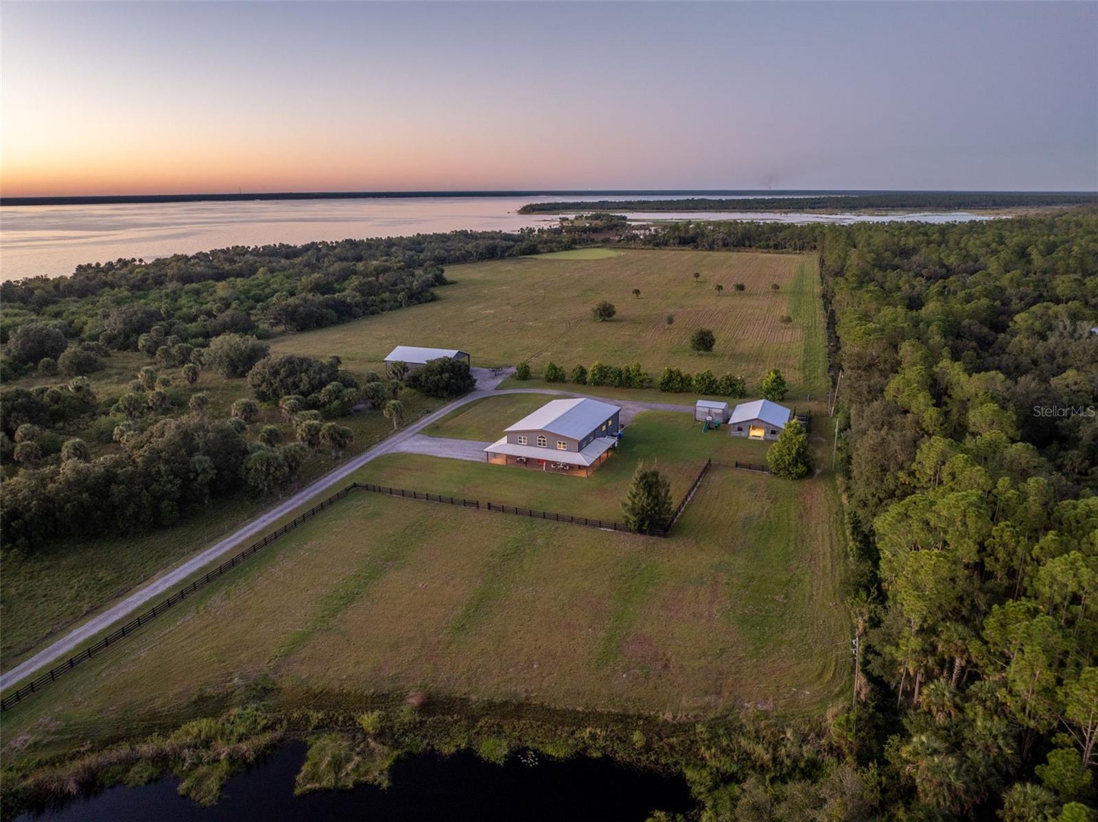 Welcome to 859 Morgan Alderman Rd — where agriculture and luxury meet! Privately tucked behind dual gates, this 52-acre, move-in-ready estate offers the perfect blend of seclusion, comfort, and functionality. The oversized barndominium features 2,200 sq ft of living space with the primary suite on the main floor. The open-concept living, dining, and kitchen areas create an inviting space for entertaining and everyday living. Upstairs, you’ll find a loft and two additional bedrooms, complete with a stairway gate for extra peace of mind. 
500gal Reverse Osmosis water treatment system, 500gal LP tank, LP appliances, and a Generac whole home generator are only SOME of the amazing features of this home as well. Attached to the home is a 2,500 sq ft garage workshop with two roll-up doors, ideal for equipment, vehicles, or creative projects. Need even more space? A detached 3,250 sq ft concrete-block shop with full slab and three roll-up doors stands ready for storage or heavy-duty work. The property also includes a 3-stall, center-aisle barn with tack and feed room—each stall matted, with two offering runs that open into larger paddocks. Nearly 30 acres of lush, uninterrupted pasture make this an ideal setup for horses or livestock. This parcel also comes with primary ownership in a contiguous parcel that fronts on Lake Harney, connecting to the St. Johns River. Additional contiguous ~200 acres available as well. Don't miss your opportunity to own a move-in ready ranch, that is convenient to all Central FL has to offer!
