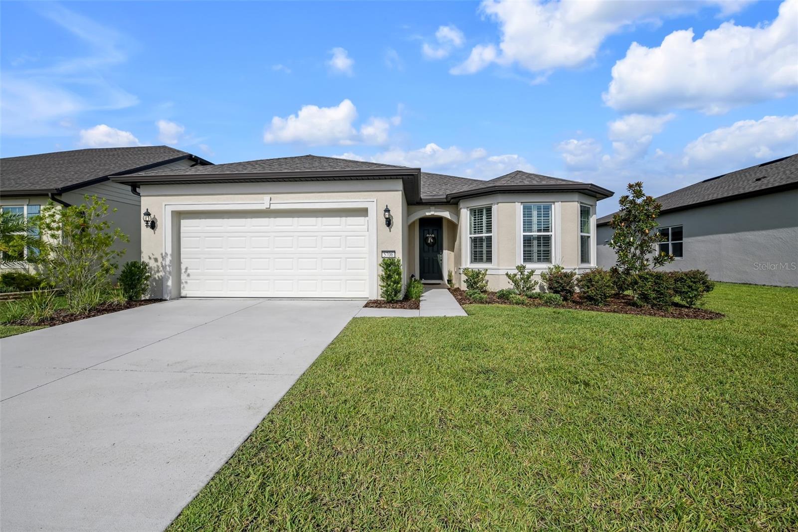 This beautiful newer (2021) Mystique, located in the active 55+ community of Stone Creek by DelWebb, with 2 bedrooms, 2 baths, additional Flex Room / Den, neutral color palette, plantation shutters throughout, luxury vinyl plank and tile flooring, and numerous additional Builder upgrades is move-in ready!  The valuable extended garage boasts a generous alcove area perfect for golf cart parking, workshop, home gym, or extra storage.  The upgraded kitchen package with quartz countertops, tile backsplash, KitchenAid stainless steel appliances, level 3 cabinets with soft-close hinges and drawers, pull out shelves, dual trash bins, corner Lazy Susan, and upgraded faucet on large center island.  The spacious adjoining Family Room and Dining area are light and bright with multiple windows and sliding glass doors to the covered screened Lanai.  The sought after Guest Bedroom provides additional square footage and light with the desirable bay window feature.  The Guest Bath has upgraded fixtures, tiled tub surround with niche, and a single vanity with quartz countertop. The expansive indoor Laundry Room is finished with cabinets, utility sink, shelving, Corian countertop, and a large HVAC/Utility closet with additional storage space.  A Flex Room with double doors is an added bonus and perfect for a home office, den, gym, game room, or hosting additional overnight guests.  The Owners Bedroom provides an ample retreat with en-suite Owners Bath containing a luxurious tiled walk-in shower with built-in bench and niche, dual sinks in a wide quartz topped vanity, spacious walk-in closet, a private water closet, and a convenient linen closet.  Stone Creek is a very active community and has many amenities to enjoy, including a main clubhouse with library, cafe, meeting rooms, ballroom with stage, catering kitchen, etc.  A new amenity building, currently under construction and scheduled to open soon, will provide additional leisure space with billiards, game tables, a golf simulator, an outdoor amphitheater, relaxing patios and outdoor game areas.  The beautiful community outdoor pool and spa complex is directly behind the Elan Spa building, which houses a full fitness center, indoor pool, indoor spa, sauna, steam room, locker rooms, and fitness classes.  Adjacent to Elan Spa there are also 5 Tennis courts, 16 Pickleball courts, 8 Bocce Ball courts, 6 Horseshoe pits, a Basketball court, a fenced raised garden plot area, a Softball field, a Dog Park, a pier with screened gazebo, and a covered Pavilion with picnic tables and restrooms.  There are miles of multi-use paved paths for golf cart, bicycle and pedestrian use throughout the community. The Stone Creek Golf Course winds through the development with a Pro Shop, Driving Range, Putting Green, Bar & Grille, and an outdoor Patio area available for the enjoyment of Members, Residents, and the Public at an additional cost.  Stone Creek is in proximity to the new Florida Aquatic Swimming and Training complex (FAST), The World Equestrian Center (WEC), Medical, Shopping, Dining, Entertainment, Golf, and I75.