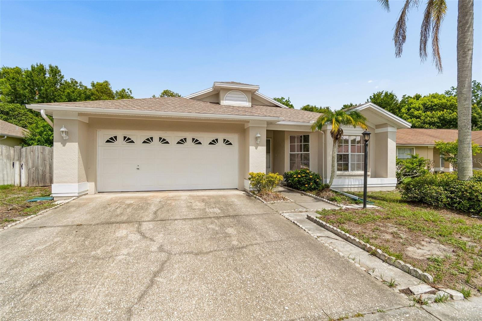 Rare find in the desirable Deer Park subdivision. This single-story 3-bedroom, 2-bath home offers almost 1,700 sq ft plus an oversized garage, all set on a private, wooded lot with NO rear neighbors. A large flex/bonus room off the kitchen features expansive windows overlooking the backyard, making it ideal as a home office, playroom, or media room. Real parquet flooring graces the living and dining rooms, with easy-care tile throughout the kitchen, foyer, primary bedroom, and bonus room, plus real wood cabinet doors in the kitchen. The vaulted, open-concept living areas offer great natural light and flow. Enjoy mature, established fruit trees including avocado, fig, navel orange, tangerine, mulberry, and grapefruit, plus young mango and banana trees. The oversized garage includes built-in shelving and a workbench, and the walk-up attic offers exceptional additional storage. Extras include a whole-home security system, a breaker box already wired for a future pool, wide side yards with room for a shed, and low average electric costs. Brand-new roof and fresh exterior paint in 2026. Enjoy easy access to Starkey Wilderness Park, nearby shopping (Publix, Sprouts, Walmart, PetSmart), and a short drive to Gulf beaches. Deer Park Elementary is a stones throw away. Don't miss this rare combination of privacy, space, and character!