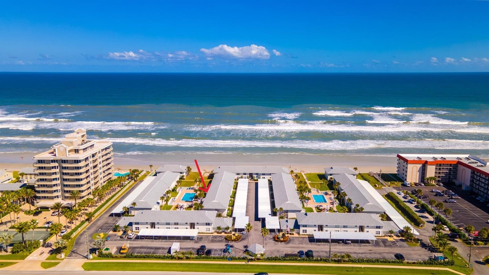 Beautifully renovated one-bedroom, ground-floor condominium overlooking resort style pool in Colony Beach Club, ideally positioned on New Smyrna Beach's car-free beach. The unit interior was meticulously upgraded with luxury appliances, wide plank tile floors, remote controlled hurricane shutters, custom built kitchen with marble countertops and luxury grade appliances, wood beamed ceilings with LED lighting, all-room Sonos speaker system, an electric fireplace, private tiled covered patio directly on the heated pool, and marble shower with stone floor, The kitchen includes a self cleaning glass top range/oven, microwave, Bosch dishwasher, Liebherr refrigerator, double stainless sink. Upgraded technology features include an electronic entry, Nest controlled HVAC, and Nest smoke alarm. Outdoor patio storage room includes washer / dryer connection. The owner converted a large closet into a stylish bunk room with custom built beds. The unit also includes an outdoor storage area with direct access to the beach and a reserved parking space. The unit interior decorating and design are truly exceptional and amongst the most high-end finishes in the community. Colony Beach Club features an impressive low-density site plan with large common areas including two pools with ample seating, beachfront lounge area, two private beach access points, a shuffleboard court, on-site management office, covered private parking, large grill areas, and a laundry center. Located on the car-free beach section of New Smyrna Beach, Colony Beach Club is ideally located between bustling Flagler Avenue and Canaveral National Seashore. The community is across from a large grocery-anchored retail center with ample restaurant and retail tenants.