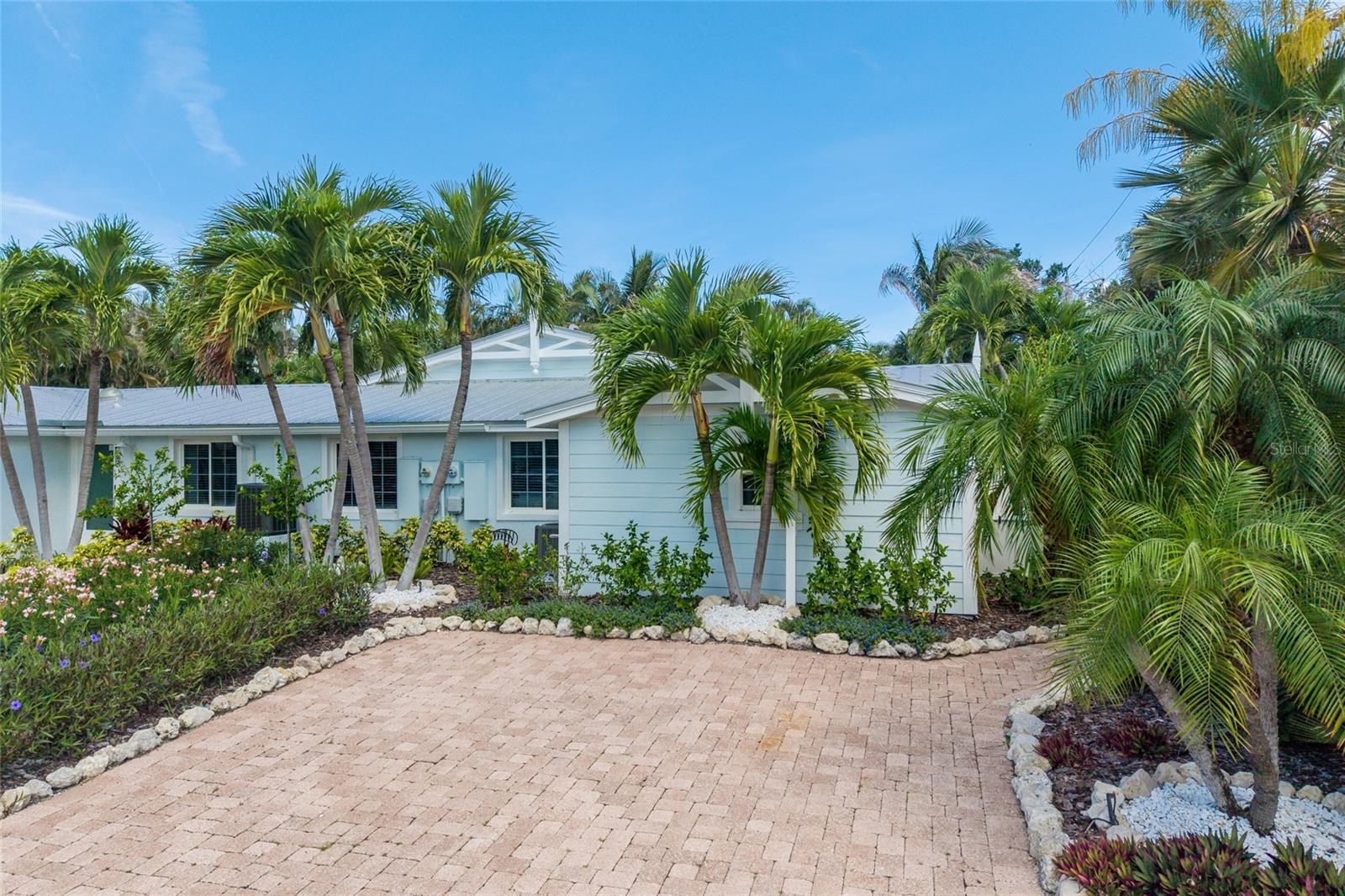 The ultimate island investment or low-maintenance personal paradise has arrived!  This fully remodeled 3-bedroom, 2-bathroom villa offers the rare freedom of zero HOA fees combined with high-income weekly rental potential. Originally built with solid mid-century bones, the property carries an effective year built of 2009 and has just undergone a spectacular, top-to-bottom luxury transformation.  Step inside to a bright, airy great room boasting vaulted ceilings and elegant crown molding throughout. The stunning chef’s kitchen features a massive island with counter seating, brand-new cabinetry, quartz countertops, and all-new Stainless Steel appliances. Total peace of mind is yours with BRAND-NEW impact-rated windows, exterior doors, and sliding glass doors, complemented by fresh interior/exterior paint and new ceramic tile flooring.  The outdoor space is a private tropical oasis, showcasing fresh landscaping with a full irrigation system/landscape lighting and a fully fenced yard. The sparkling heated pool is ready for year-round enjoyment with a brand-new pool heater and pool pump. Offered completely turnkey furnished, this island gem is move in and rental-ready from day one!