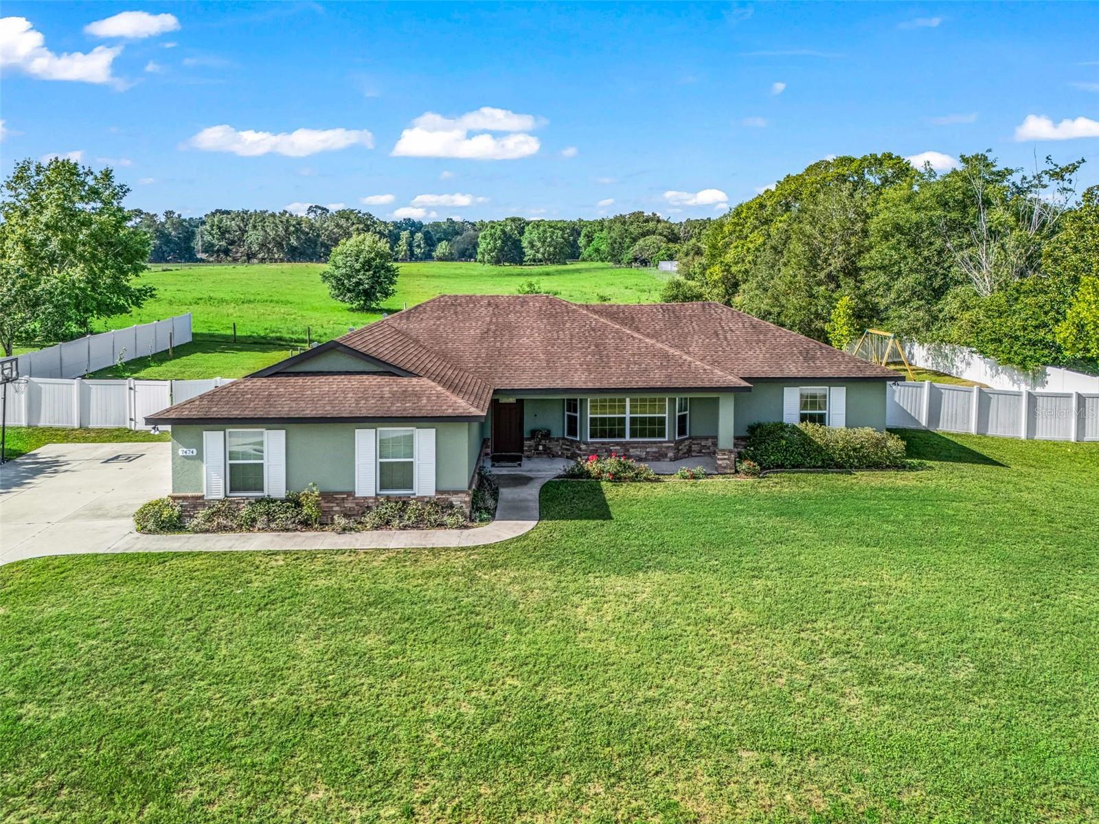 This charming 3-bedroom, 2-bath home features a split floor plan designed for comfort and privacy. The sidewalk from the driveway leads to a welcoming front porch and a screened-in lanai that overlooks peaceful equestrian pastures, where you can often enjoy views of beautiful horses. The backyard is mostly fenced with durable vinyl fencing on three sides, while the rear portion uses farmer’s wire fencing to maintain an unobstructed view of the pasture.  Situated on a spacious 0.41-acre lot in the desirable Green Meadows area of Belleview, this home offers plenty of room for gardening and outdoor activities. Located on a quiet dead-end street that also borders pastureland, the setting is peaceful and private.  Built by the seller’s father, a respected local builder, in 2018, the home includes a relatively new roof and mechanical systems that are about eight years old. Please note, bookshelves do not convey with the property.  
Don’t miss the opportunity to see this lovely home in person.