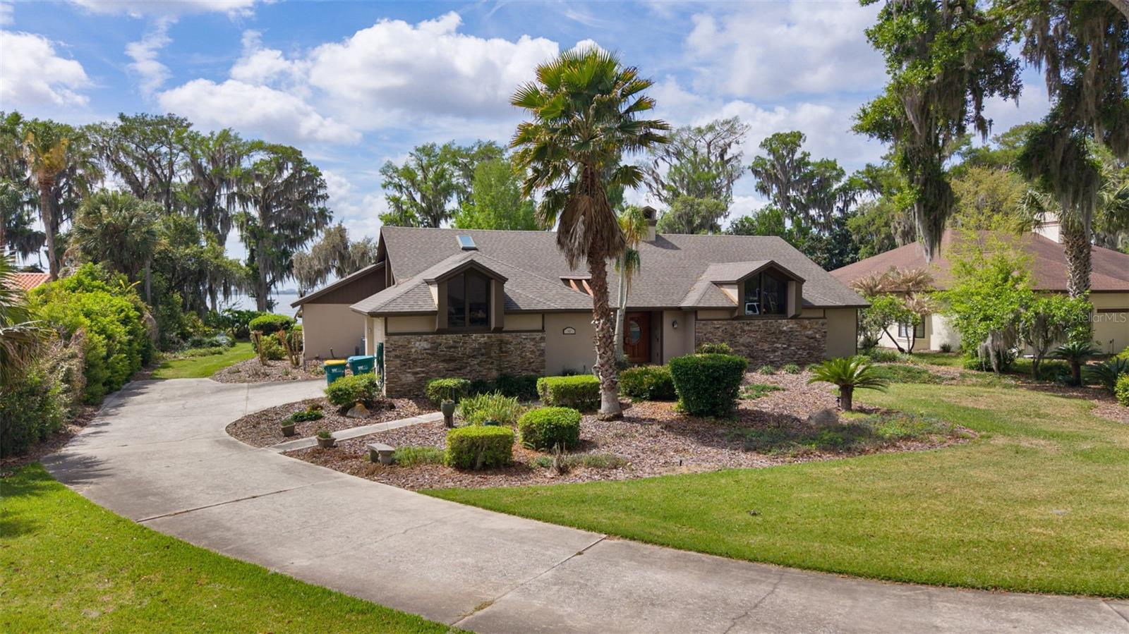 Truly a "florida lifestyle" Pool home, tucked away in a lovely 1 streeted, very small community, on lake Harris. Current owners have done so much of an upgrade to this home. In the kitchen they moved the stove top to the island with custom island and ventless cooktop, new cabinetry and lighting, new fixtures, new pantry. In the great room new bookcases with lighting... down the hall There is a third bedroom. They turned a film, darkroom into such a nice full bath. Brand new luxury vinyl plank flooring in the house. In the primary bedroom, A New big walk in closet. Upon entry of the front door, you walk into a massive great room with kitchen and dinette area at one end. From the great room, you're overlooking the pool area and still have a great view of the lake. Primary bedroom on one end With large bathroom. In the hallway is a 1/2 bath. On the other end of the house down the hall , you have the laundry room, a second bedroom, a full bath in the hallway and a third bedroom at the end of the house overlooking the lake , with its own full bath. Massive pool area, screen in, covered area. Grilling and chilling. Beautiful backyard facing the lake.. walk out on to the pier, enjoy fishing from the pier, or put that boat in the water and enjoy a ride to the tiki bars within minutes of this location. Come and enjoy Florida for all.It has to offer.