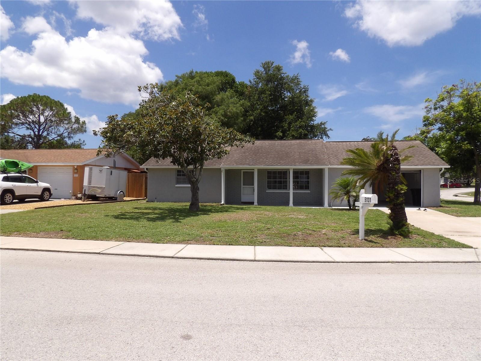 Beautifully Updated home. This solid concrete-block home, built in 1974, offers 1,176 sq ft of living space on a spacious 7,000 sq ft corner lot, making it an ideal primary residence or investment opportunity. Inside, you’ll find an open floor plan, 2 bedrooms, 2 full bathrooms, and tile flooring throughout for easy maintenance. The versatile Florida room can be converted into a third bedroom, guest suite, or flex space to suit your needs.Recently painted inside and out, this home has a fresh, modern feel that's truly move-in ready. Step outside to the 12' × 14' covered lanai — ideal for morning coffee or winding down in the evening. The oversized one-car garage (approx. 540 sq ft) offers serious storage or workshop potential well beyond what standard garages provide. An in-ground irrigation system keeps the landscaping effortless, and the partially fenced backyard with mature shade trees creates a genuinely private, peaceful retreat right at home.Nestled in the quiet and established Tanglewood Terrace neighborhood, this home sits in a non-flood zone and has no HOA restrictions, offering freedom and peace of mind. You’ll love the convenience of being just minutes from shopping, recreational complexes, Gulf beaches, state parks, and nature preserves.This is a rare opportunity to own a well-maintained home in one of New Port Richey’s most desirable and accessible areas.