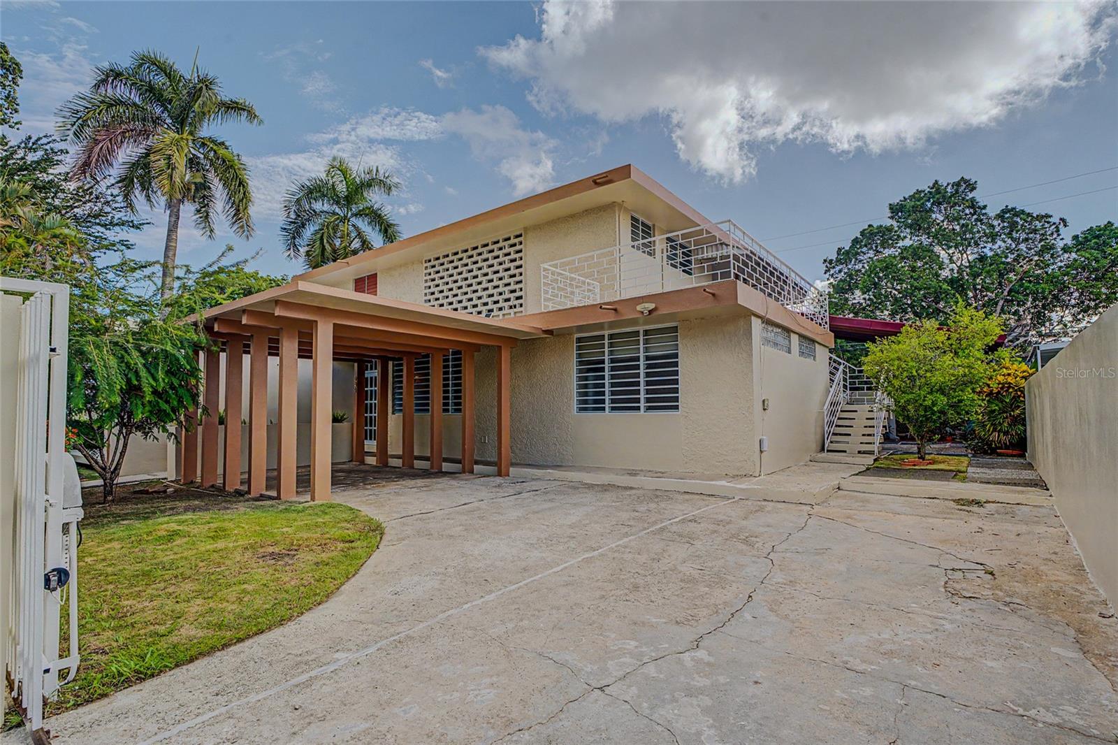 Income-producing opportunity located in the desirable University Gardens community of San Juan. Situated on a corner lot in the heart of the metropolitan area, this property offers approximately 3,065 square feet of living area on a generously sized lot, providing a combination of interior and outdoor space not commonly found within the neighborhood. Featuring two independent living units with separate water and electricity meters, it presents an excellent opportunity for owner-occupants seeking supplemental rental income or investors looking for long-term rental potential.

The property consists of a 3-bedroom, 3-bathroom main residence featuring a dedicated office that offers additional flexible living space, along with two living areas, a functional kitchen, a spacious terrace/patio, and owned solar panels that help reduce monthly electricity costs. The spacious main residence, with three independent entrances, offers additional flexibility for future reconfiguration, subject to buyer verification and applicable regulations. The main residence is currently vacant, offering immediate occupancy or the opportunity to lease at market rates.

The second unit features 2 bedrooms, 1 bathroom, a comfortable living and dining area, a functional kitchen with an adjacent laundry area, a private balcony, and a bright enclosed flex space ideal for a home office, reading nook, hobby room, playroom, or additional sitting area. This unit offers excellent flexibility for rental income, multigenerational living, guest accommodations, or extended family.

Conveniently located near major expressways, universities, hospitals, shopping centers, restaurants, and business districts, the property enjoys a central San Juan location with strong rental appeal.

Whether you're looking to expand your investment portfolio or purchase a home with an existing income-producing component, 901 Calle Harvard offers a practical combination of comfortable living and rental potential in one of San Juan's most established residential communities.

Schedule your private showing today.