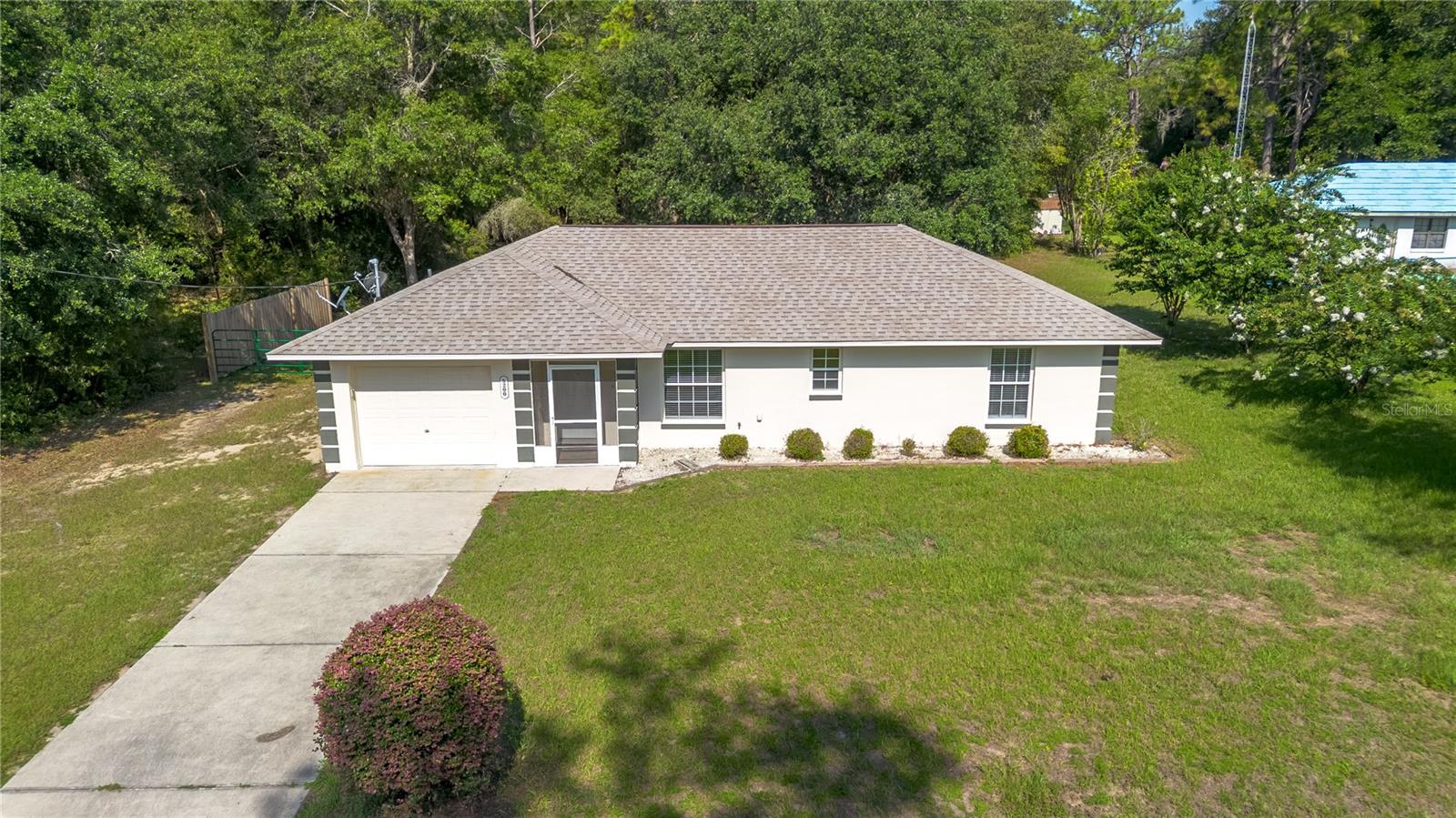 Set on just under an acre within Rainbow Acres, this well-maintained 2-bedroom, 2-bath home offers the perfect blend of privacy, comfort, and convenience! Accented by tasteful landscaping and a welcoming screen-enclosed entryway, the home offers plenty of curb appeal, complemented by the added value of a new roof and HVAC system installed in 2022. Inside, the home features an inviting open floor plan with lots of natural light and wood-look flooring throughout. The kitchen is nicely updated with stone countertops, lots of cabinet storage, stainless steel appliances, and tiled backsplash. The primary suite is perfect for relaxing, with a walk-in closet and a private en-suite bath with glass-door shower and updated vanity. The secondary bedroom features lovely built-in shelving, making it a great option for those looking to display their collections or set up a home-office. At the back of the home, the screen-enclosed lanai overlooks the spacious backyard, which provides plenty of space for gardening, outdoor entertaining, and future additions. The attached 1-car garage is equipped with lots of storage and workspace, adding to the property’s functionality. Located just a short drive from Dunnellon, Ocala, and Crystal River, this property also places you close to some of the area’s best outdoor recreation! Spend your days kayaking, tubing, paddleboarding, or fishing on the crystal-clear waters of the Rainbow River or Rainbow Springs State Park, explore miles of trails and wildlife habitat in the Goethe State Forest, or enjoy cycling, walking, and running along the scenic Withlacoochee State Trail. This property offers the opportunity to enjoy peaceful country living with easy access to the natural beauty that makes this area so desirable– don’t miss out!