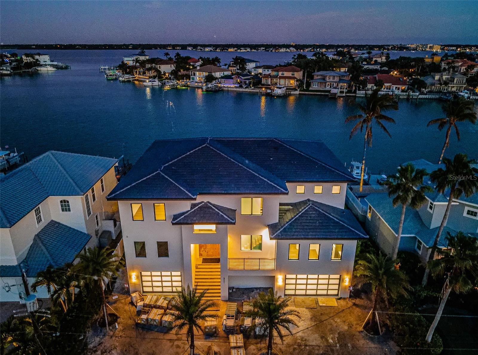 THE FIRST BRAND NEW CONSTRUCTION (NEVER LIVED IN) WATERFRONT HOME AVAILABLE FOR SALE IN BELLEAIR BEACH IN 7 YEARS!  Welcome to the lap of waterfront luxury.  Three floors of steel-reinforced concrete construction and a striking designer-concrete tile roof, support the brilliant amenities and inspiring finishes of this stunning coastal contemporary estate.  Tall 11ft-high ceilings, posh wide-plank wood flooring, spectacular commercial-grade all-glass railings, radiant Fine Art Handcrafted lighting, Euro-style frameless cabinetry, and an incredible custom open floorplan deliver an unforgettable living experience.  Hand-forged steel double door entry opens to dazzling views of your beautiful waterfront. Soaring 25ft-high living room transitions to a wide, luxurious covered balcony with sweeping open water views.  Sumptuous gourmet kitchen features true quartzite counters, Wolf double gas range, Sub-Zero refrigeration, Thermador wine column, Waterstone faucets, a gleaming island bar, and an exceptional butler’s pantry with superb, separate appliances.  Waterfront dining area provides kitchen-matching built-in buffet.  Grand upper-level family room introduces the lavish owner’s suite with commanding views of the waterfront and private access to a gorgeous 24ft-wide covered waterfront balcony.  The posh, pampering owner’s bath is adorned in alluring Italian Marble – with exquisite dual vanities, rich stone soaking tub, a scintillating glass-enclosed dual shower, and two large walk-in closets.  2nd bedroom suite overlooks the waterfront; all bedroom suites are huge, with luxuriously-appointed baths and walk-in closets.  Step out back and indulge in the impressive, fully automated pool/spa overlooking the water – a picture perfect paradise.  Elegant laundry rooms on both living levels, 13-car garage parking, natural gas, tankless hot water heating, new dock/seawall for deep-water boating, solid core doors, all glass garage doors, three Bosch inverter A/C systems, Three-stop commercial-grade elevator, advanced internet/media wiring, concrete-paver driveway, extensive landscaping package, and so much more.  Built to exacting standards with high-quality materials and uncompromising attention to detail, this residence will exceed the needs of the most discriminating of buyers.  Short three-minute walk to the private beach, easy 10-minute boat ride to the Gulf.  A rare opportunity in Belleair Beach!  All dimensions are estimates, buyer to verify dimensions.