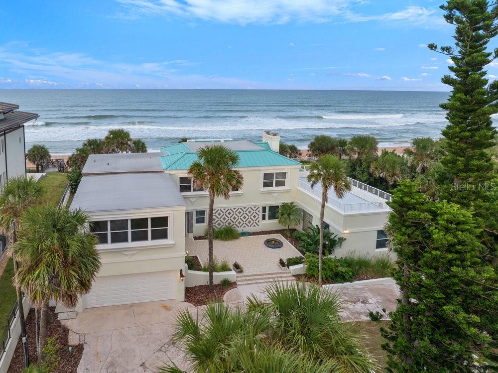 285 Ocean Shore Blvd. is a residence of timeless significance and enduring charm. Nestled just north of Granada Boulevard in the heart of Ormond Beaches Oceanfront, this exclusive street has long been the choice of visionaries—car dealers and manufacturers, prominent physicians and attorneys, and CEOs of publicly traded companies. It remains one of the area's most premier and sought-after locations. From the street, a circular driveway introduces the estate, where a serene sitting area with a fountain sets the tone. The walk up to the home showcases a stately veranda, accented by another fountain and four striking mosaic tile inlays, creating a grand first impression. Inside, the nearly 700 sq. ft. great room commands attention with its soaring scale and panoramic window complete with a built-in bench perfect for savoring endless Atlantic Ocean views. The adjoining kitchen and dining area are wrapped in window walls on three sides, filling the space with natural light and coastal vistas. The kitchen features a granite island with cooktop, prep sink, and ample storage below, while a French-door pantry provides generous space for dry goods and entertaining essentials. The grande staircase, adorned with one-of-a-kind marble steps and a custom wrought iron and wood railing, ascends to the second floor to the primary suite, which is a true retreat, featuring a cozy oceanfront nook, a private balcony, and a spa-inspired bath with dual vanities and a Jacuzzi tub all oriented to capture serene ocean views and the secondary large bedroom and bath. Two additional bedrooms complete the upper level, including another suite that opens to a spectacular deck with breathtaking views stretching from the ocean to the golf course. Bonus room / possible 6th bedroom is also found on 2nd floor. Square footage received from tax rolls. All information recorded in the MLS intended to be accurate but cannot be guaranteed.