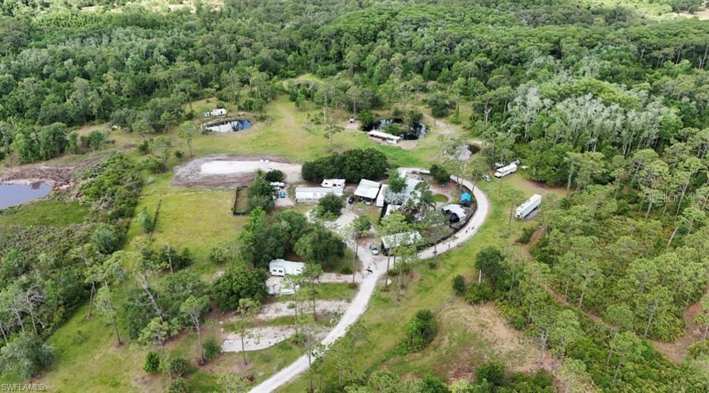 Exclusive 20-Acre Investment Property Designed for Multiple Income Streams. Discover a truly rare opportunity to own an exceptionally improved 20-acre estate designed to support multiple revenue opportunities and a wide range of agricultural, Hunting, recreational, and commercial ventures. Originally developed for agricultural use, this versatile property is equipped to maintain big and small birds, poultry, fowl enclosures, a rabbitry, goat and small livestock pens, and a fully outfitted feed room. Beyond the animal facilities, the fully fenced grounds offer four stocked fish ponds, additional fenced pasture areas for grazing livestock, an expansive garden area, and an elevated barn pad constructed with approximately 80 loads of shell rock—creating an ideal foundation for future expansion. A charming 2-bedroom, 1-bath mobile home provides on-site living accommodations or potential caretaker housing. Eligible for an agricultural exemption, the property is surrounded by mature trees and established landscaping that create a private, peaceful setting rarely found at this scale. the Lovely property is only 10-15 minute drive to Labelle shops Whether envisioned as an income-producing agricultural enterprise, animal services operation, sporting retreat, hobby farm, or private countryside estate, this extraordinary property offers the infrastructure, flexibility, and vision to bring countless possibilities to life.