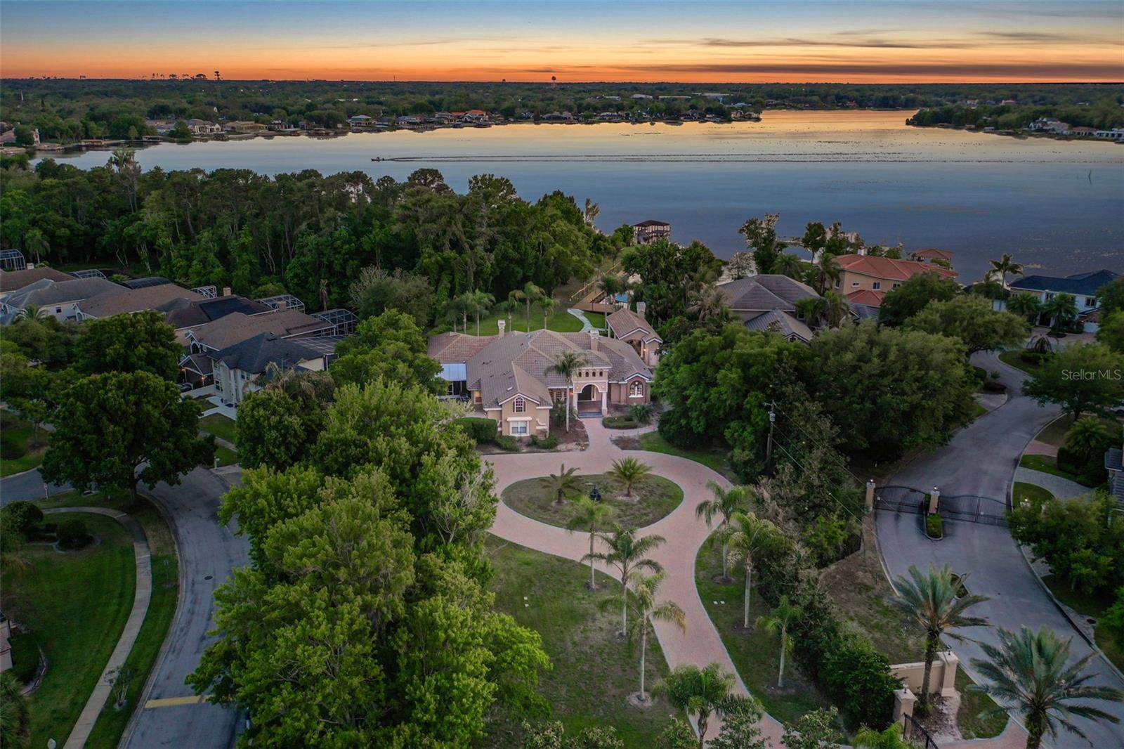 Once-in-a-lifetime opportunity to own a privately gated estate on acreage(12 total acres, approx 3 dry) along the pristine shores of Lake Brantley. This astounding 5-bedroom, 5.5-bath estate welcomes you through a striking private gated entrance, featuring a grand circular driveway, lush landscaping, and a tranquil fountain. Enjoy the pinnacle of true privacy with seemingly endless land. Thoughtfully designed, the home showcases elegant formal living and dining rooms, along with a private office complete with custom built-ins.  Upon arrival, the soaring ceilings showcase an open and airy floor plan with loads of natural light throughout. The spacious primary suite, located on the west wing, offers a luxurious retreat with a jetted tub, while two additional bedrooms—each with en-suite baths—are positioned on the east wing for added privacy. Upstairs, a secluded guest suite provides its own bedroom, bathroom, and living area. At the heart of the home, the expansive kitchen overlooks the family room and opens seamlessly to the pool and covered patio, creating an ideal space for everyday living and entertaining, all with incredible views of Lake Brantley. Additional highlights include an oversized game room, a secondary living room, and a dedicated private guest bedroom with an en-suite bath. The outdoor living space is meticulously crafted for both privacy and entertaining, featuring a resort-style cabana with granite countertops, a commercial-grade grill, fireplace, ice maker, beer tap, refrigerator, and built-in TV; all with breathtaking vistas and the privacy only acreage can offer. An exceptional setting designed for refined entertaining and unforgettable moments. Embrace the lakefront lifestyle—whether boating, skiing, or simply unwinding as breathtaking sunsets paint the horizon. A charming wood dock extends to your second private dock, complete with a lift and covered space, offering both convenience and elegance.  Indulge in the serene ambiance as gentle waters ripple along the shoreline, creating a sense of tranquility unique to this one-of-a-kind residence. Enjoy leisurely afternoons on the pristine 288-acre lake, known for its crystal-clear waters and rare sandy-bottom shoreline—ideal for fishing, skiing, or peaceful relaxation. As evening falls, savor a glass of wine from your reserved sunset vantage point, where the golden hues give way to moonlit reflections dancing across the water. Perfectly positioned in a highly desirable location, this residence offers effortless access to premier shopping, fine dining, major thoroughfares, and top-rated schools. Must be seen to be believed. This property may be under audio/visual surveillance.
