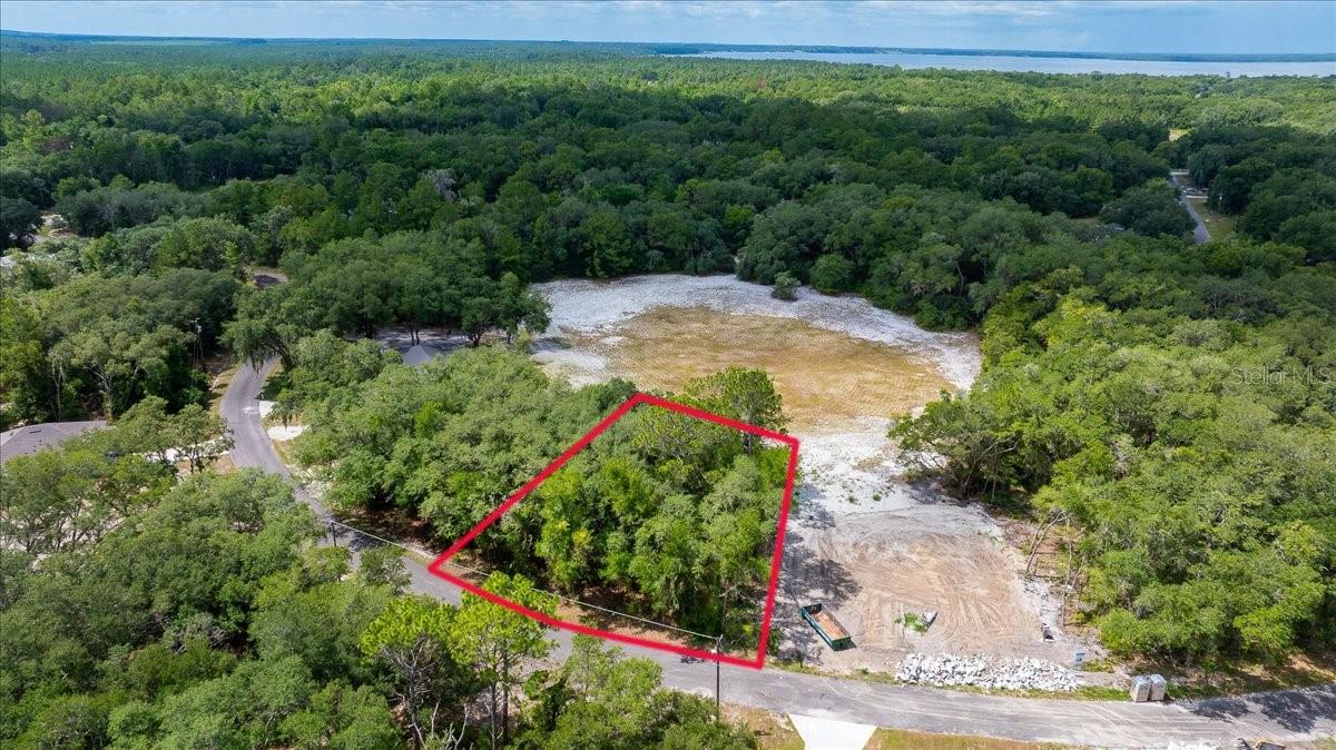 Vacant residential lot on Fisher Lane Ct in Ocklawaha, Marion County. 0.23 acres, single-family construction only. Paved road access, no HOA. Backs to a dried retention pond, no rear neighbors. Located off SE 145th Ave, about 11 minutes to East Lake Weir. No utilities on site, well and septic required.
