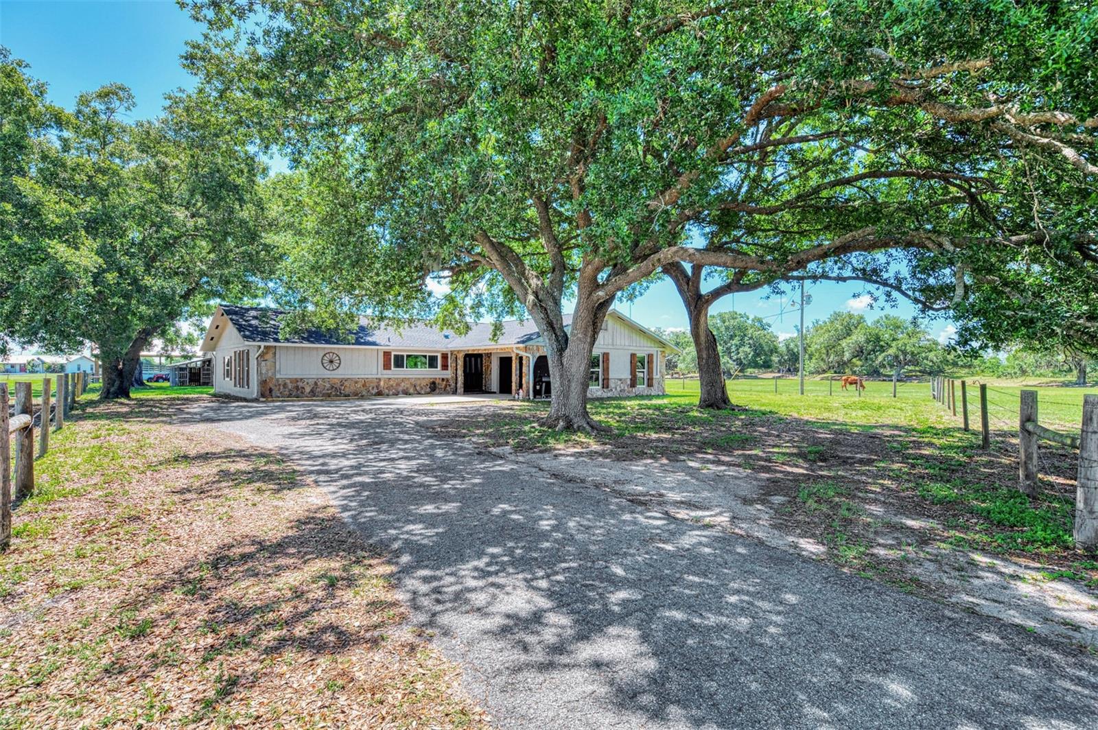 DON'T MISS THIS ONE!!  BRING YOUR FARM ANIMALS, TOYS, AND FURNITURE!! This stunning modern farmhouse on over 10 acres is everything you’ve been waiting for!! Located in one of the most desirable areas of DeSoto County, this beautifully updated 4-bedroom, 2-bath home perfectly blends rustic farmhouse charm with stylish modern finishes. Inside, you’ll find shiplap accents, exposed beams, and sliding barn doors paired with granite countertops, stainless steel appliances, subway tile, and thoughtfully designed living spaces throughout.  This property is loaded with upgrades and features for peace of mind living including a NEW ROOF in 2023, newer HURRICANE IMPACT WINDOWS (2020), newer septic system (2017), an updated two-zone A/C system with new ductwork, a huge bonus room, an oversized two-car garage, workshop space, a BRAND NEW POLE BARN, and so much more!! The paved driveway and automatic gated entrance add convenience and privacy from the moment you arrive. If you love the outdoors or want to try your hand at farming, you will love the impressive outbuildings, including a large barn with covered storage for ATVs, boats, or equipment, plus enclosed workshop/man cave space, hay storage, and even a chicken coop!!  The property is fully equipped for country living with both a traditional deep well for the home and an artesian well for livestock watering. Add a garden and create your own private, self-sustaining retreat!! Backing up to the beautiful RV Griffin Reserve and situated at the end of the street with minimal traffic, this peaceful property offers privacy, scenic views, and a small creek running through the land — perfect for HORSES or CATTLE!! Rarely does a property combine modern updates, functional acreage, and farmhouse character quite like this one.  And it's ideally located (NOT IN A FLOOD ZONE!!) close enough to shops, restaurants, golfing, and HISTORIC DOWNTOWN ARCADIA, yet far enough to get away from it all!!  Call today to schedule your private tour!!