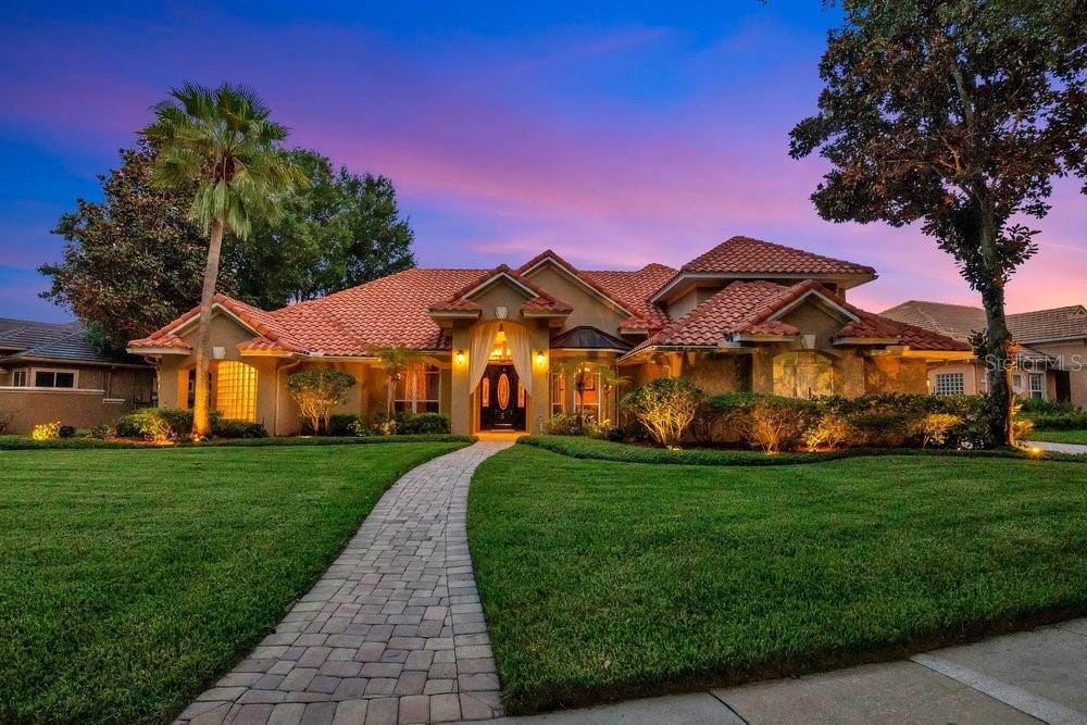 Situated behind the Gates in one of MetroWest's Premiere Communities - Palma Vista.   From it's Stunning Curb Appeal, Tasteful Landscaping and Desirable Floorplan, this Mediterranean Inspired Executive Home may be just what you've been looking for,  Upon entering this Home you will notice the gorgeous Travertine Floors throughout a good portion of the Home.  Living Room Features a unique Coffered Ceiling and French Doors leading to the Lanai and Pool.  The Formal Dining features a Double Tray Ceiling and large Windows adorned by Beautiful Draperies.   At the rear of the Home is an Open Kitchen/Family Room Combo and a Kitchen Nook with Mitered Glass Windows.  Kitchen features 42" Upper Cabinetry with Crown Molding, Gorgeous Granite Counters and Backsplash, Pantry and Stainless Steel Appliances including a Commercial-style KitchenAid Refrigerator, Dishwasher Drawers and newer Cooktop.  The large Family Room boasts a Gas Fireplace, large Windows showcasing the Backyard and beautiful French Doors leading the the Lanai and Pool.  Off the Family Room are Two Bedrooms with Jack and Jill Bathroom.  At the opposite side of the Home you will find a sizeable Primary Suite with Bonus area that would make a wonderful Sitting area, Office Nook or Nursery...you choose!  This Bedroom features French Doors leading to the Lanai and Pool along with elegant Window Treatments which Convey.  The Primary Bathroom offers Dual Vanities, Water Closet and Two Walk-in Closets with the Centerpiece being a Double Glass Block Wall Shower, which diffuses Sunlight beautifully while offering seamless privacy - a True Architectural Statement! Near the Primary Suite is the 4th Bedroom, which is currently set up as a Walk-in Closet for the Primary, complete with Custom Cabinetry, Island Dresser and Chandelier!  Additionally, Downstairs you will find a completely remodeled Full Pool Bath, Laundry Room with Large Storage Closet and 3-Car Garage.  Upstairs is a beautifully Styled Media Room with Large Built-in Wall of Cabinetry and Wet Bar Featuring Beverage Cooler (86" TV, two smaller TV's, 5 ONKYO Speakers and Media Room Audio Equipment will Convey).  This space could also be transformed into a Secondary Primary as it offers a completely remodeled Full Bathroom and Walk-in Closet just outside the rooms entry.  The rear Pavered Lanai offers an abundance of Covered Outdoor Living Space for Entertaining.  A Sparkling Lagoon-Style Swimming Pool and Spa with Water Features make for a Tranquil Retreat.  The rear yard boasts producing Mango and Avocado Trees.  Barrel Tile Roof has recently been cleaned.  Additional features include: Two New AC Systems in 2025, Pool Pump 2025, ADT Security System and outdoor landscape lighting.  Conveniently located near Dining, Shopping and major Roadways.