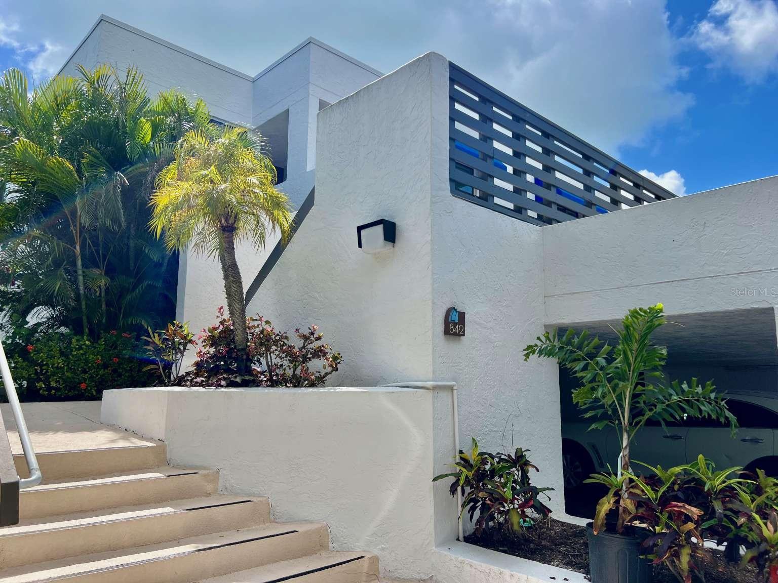 This exceptionally clean and well maintained 2-bedroom, 2-bath residence in Bayport Beach and Tennis Club is offered turnkey (with a few exclusions), ready for immediate enjoyment. Currently the lowest-priced unit in the community, it also presents a rare opportunity for a new owner to customize and renovate at their own pace—adding personal style while building value. Ideally positioned as a bright and private second-floor end unit with no neighbors above, this home is filled with natural light. Kitchen, dining, living room open design with split bedrooms for privacy. The primary suite features a walk-in closet and a dedicated office niche—perfect for today’s work-from-home lifestyle. Two inviting outdoor living spaces—a private open-air deck and a screened lanai overlooking the tropical gardens—create the perfect setting to relax and unwind. Additional highlights include covered parking, ample guest parking, two private storage areas plus an owner’s closet, and the convenience of an in-unit full-size washer and dryer. Set on 27 acres of beautifully landscaped grounds on Longboat Key, Bayport is a sought-after gulf-to-bay community designed by renowned architect Tim Seibert. Residents enjoy 1,200 feet of deeded private beach access along the Gulf of Mexico. Community amenities are exceptional, including a Junior Olympic-size heated pool—one of the largest on the Key—four Har-Tru tennis courts, a fitness center, fishing pier, and kayak launch. Beach chairs and umbrellas are provided, and a full calendar of seasonal social activities fosters a vibrant yet relaxed coastal lifestyle. Meandering shell pathways and meticulously maintained tropical landscaping complete the serene setting. Experience the best of island living with breathtaking sunrises over the bay, unforgettable sunsets on the beach, and everything in between.