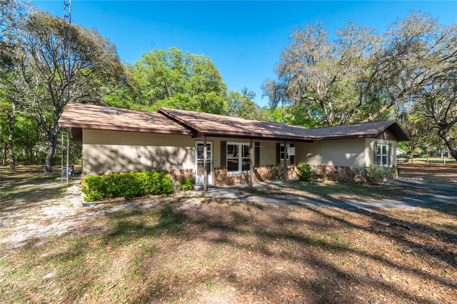 Set on approximately 2-acres in the quiet neighborhood of Vermillion Estates, this inviting countryside estate offers a convenient option for those looking to be near both Ocala and The Villages. Offering over 2,200 sqft of space, the 3-bedroom, 2-bath home features a thoughtfully designed split-bedroom layout with vaulted ceilings and lots of light throughout. The kitchen is nicely appointed for those who enjoy cooking with stainless steel appliances, ample cabinet and counter space, and a center island. The kitchen flows seamlessly into the dining and living areas, creating an open and functional layout ideal for everyday living and gatherings. The living room is anchored by a striking stone fireplace with electric insert, adding warmth and character to the space. A family room rests just beyond the living area, offering abundant natural light and plenty of space for relaxation. Those who work from home will enjoy the additional office, which features built-in shelving and could easily be used as an additional bedroom, hobby space, or play area as desired. Each bedroom is warm and inviting, but the primary suite features an extra spacious layout and a private en-suite bathroom. A dedicated laundry area adds even more convenience for everyday chores. Outdoor living is equally appealing, with a large screened-enclosed patio that provides plenty of space for outdoor seating and plenty of space for entertaining. Fenced and gated, the property features large yards that are gently shaded by mature trees, providing plenty of flexibility to enjoy the year-round sunny weather. An additional shed with covered area is in place for yard equipment and additional storage options. A short drive to either Ocala or The Villages opens up a variety of shopping, dining, entertainment, and medical options, and there are a variety of outdoor recreation options nearby. If you’re looking for the perfect blend of rural charm and everyday ease, look no further!