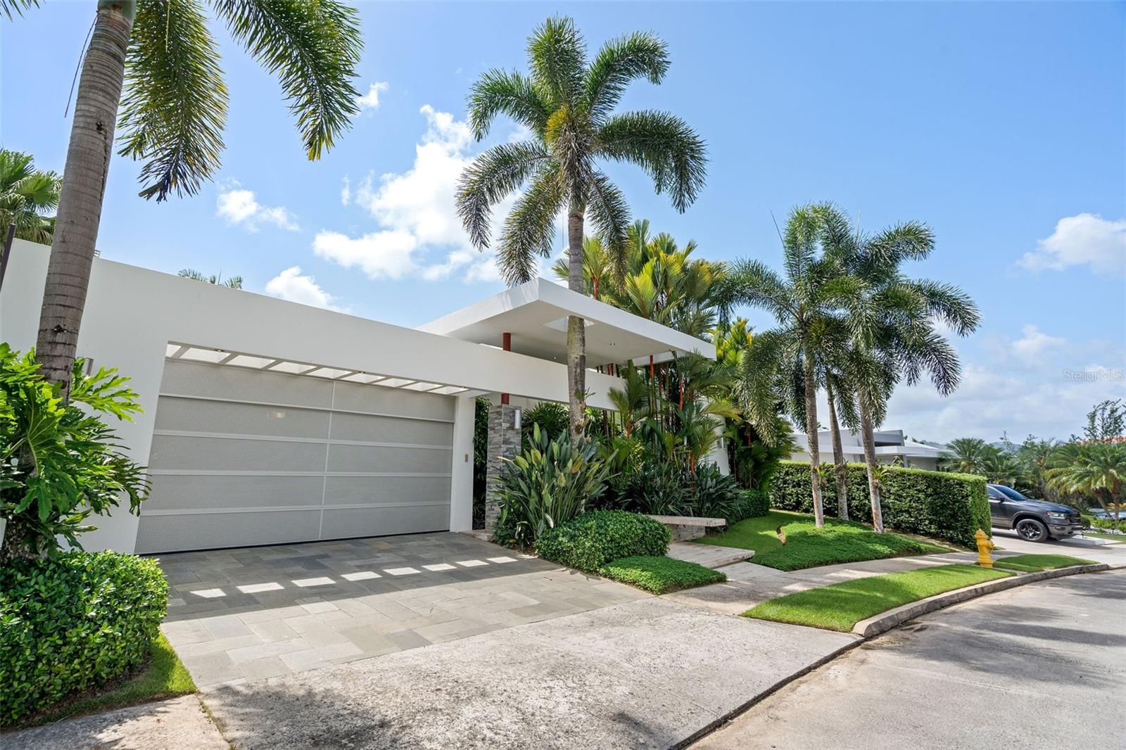 This exquisite residence located in Paseo San Juan, inside Los Paseos Community. This luxurious, fully furnished house offers an unparalleled living experience with its high-end amenities, spacious layout, and breathtaking features.

Featuring 4 bedrooms, each with its own bathroom and spacious closet space. In addition to the bedrooms, this remarkable home boasts an additional media room, perfect for entertaining or enjoying movie nights with family and friends. The big, open, and bright spaces throughout the house create an inviting atmosphere, making it an ideal place to relax or socialize. Attention to detail and fine craftsmanship can be seen throughout. The house is fully furnished with luxury top-of-the-line appliances and high-end furniture, ensuring a lavish and comfortable lifestyle. From the moment you enter, the abundance of natural light, skylights, and security windows and doors create an inviting and secure ambiance.

The well-appointed kitchen is equipped with a new, state-of-the-art cookstove with an osmosis system, perfect for culinary enthusiasts. A spacious pantry provides ample storage space for all your kitchen essentials. Additional features of this exceptional property include a generator, a water cistern, security cameras, and more, ensuring your comfort and safety. The house is equipped with a new central AC system, guaranteeing a cool and comfortable environment even in the warmest of Puerto Rican summers.

The patio is a true tropical oasis, with lush greenery that transports you to a secret garden. The stunning landscape design complements the serene ambiance, allowing you to relax and unwind in tranquility. Enjoy the refreshing pool, adorned with mosaics, and heated by a solar heater for year-round enjoyment.

Additional features of this exceptional property include a generator, a water cistern, security cameras, and more, ensuring your comfort and safety. The house is equipped with a new central AC system, guaranteeing a cool and comfortable environment even in the warmest of Puerto Rican summers.

Located in the coveted Los Paseos Community, residents of Paseo San Juan have access to a wide range of high-end amenities. Enjoy the convenience of a prestigious neighborhood, where upscale shopping, dining, and entertainment options are just moments away.