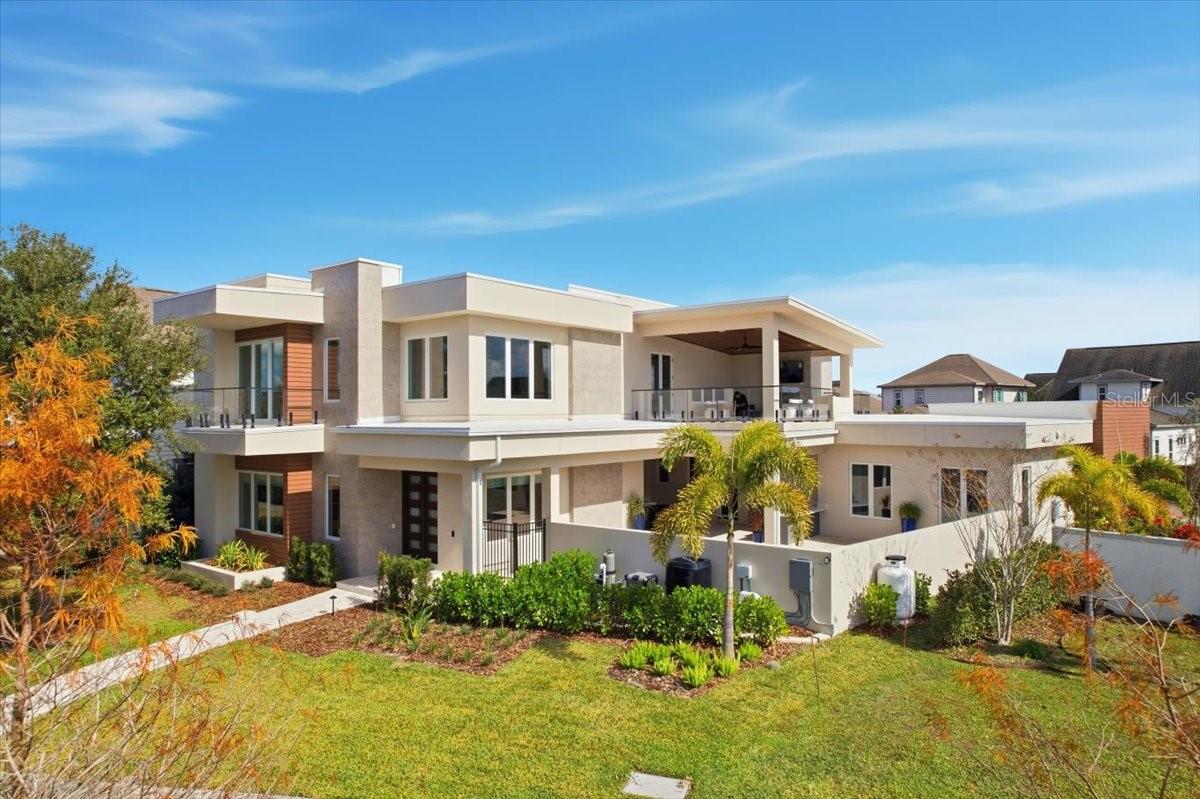 This exceptional DeVoe Custom Home is a showcase of architectural mastery, contemporary craftsmanship, and elevated modern living, perfectly positioned in the heart of Lake Nona’s Laureate Park, a community celebrated for its wellness-focused lifestyle and innovative design. Offering 4,460 square feet of thoughtfully curated living space, the residence offers 4 bedrooms and 4 bathrooms, with the flexibility to transform one bedroom into a private office. Every room and window offers stunning views from every angle, ensuring natural light and captivating scenery throughout the home.
The arrival experience is unforgettable, highlighted by a striking floating glass staircase that serves as a sculptural focal point, immediately setting the tone for the home’s elevated, modern aesthetic. Throughout the residence, premium quartz surfaces, bespoke finishes, curated designer lighting, and soft-close cabinetry reflect a meticulous commitment to quality and architectural integrity, while abundant storage solutions throughout ensure every space is as functional as it is refined.
At the heart of the home, the chef’s kitchen is designed for both culinary excellence and effortless entertaining. Outfitted with Sub-Zero appliances, custom cabinetry imported from Spain, and soft-close drawers, the space flows seamlessly into the main living areas, making it equally suited for intimate dinners or lively gatherings.
The first-floor primary suite is a true private sanctuary, thoughtfully designed with wellness and luxury in mind. The spa-inspired bathroom is a study in indulgence, featuring heated floors, a glass-enclosed soaking tub and shower for a resort-style experience, and a color-changing Bluetooth-enabled sauna. Floating cabinetry, illuminated LED mirrors, and a custom walk-in closet with built-in organization complete the suite, showcasing the home’s intentional attention to detail and craftsmanship.
Upstairs, a theater room and expansive bonus living area with a mini kitchen equipped with commercial-grade appliances provide exceptional versatility. With direct access to a private balcony and a separate exterior entrance, this level can function beautifully as a guest suite, multigenerational living space, or secluded retreat, all with sweeping views from every vantage point.
One of the home’s most captivating features is the expansive balcony overlooking the lake, a rare offering in Laureate Park, designed to frame sweeping water views and extend the living experience outdoors. The main-level outdoor spaces are equally impressive, featuring a luxury custom pool with lake views and a fully equipped summer kitchen, creating the ultimate setting for seamless indoor-outdoor entertaining.
The two-car garage is designed for both function and luxury, complete with a car lift, custom racks, built-in cabinetry, and abundant storage, offering a highly organized and versatile space for automotive enthusiasts or hobbyists. The home also benefits from three distinct points of entry: a front entrance facing the lake, a rear entry near the garage, and a private side entrance — providing added privacy, convenience, and natural flow throughout the property.
This DeVoe Custom Home represents a rare opportunity to own a residence of architectural distinction, where refined design, uncompromising craftsmanship, and modern luxury converge in the heart of Lake Nona’s Laureate Park, with breathtaking views from every room and every window.