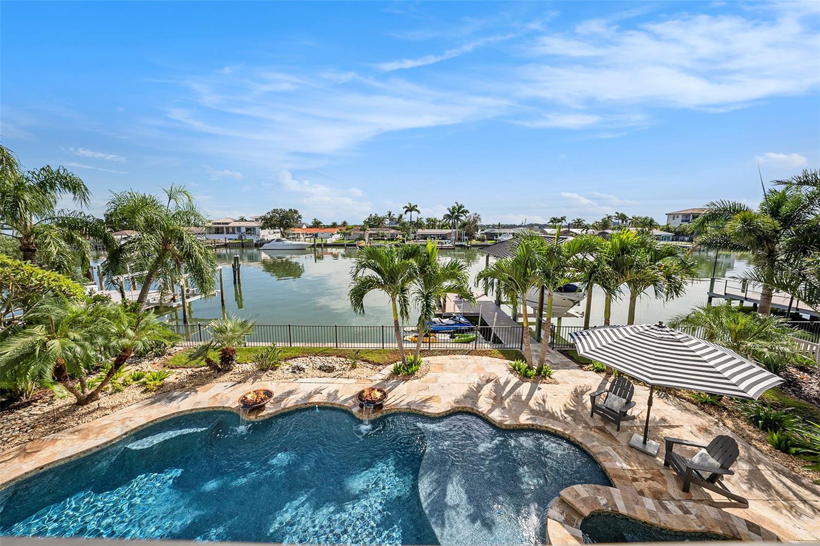 Experience refined coastal living with just the right amount of Florida flair in this elegant Spanish Mediterranean waterfront residence, perfectly positioned on the sparkling Intracoastal waters of Clearwater Bay. Think luxury, sunshine, salt air, and enough waterfront charm to make your friends suddenly “available” every weekend.

Move-in ready and partially furnished with curated Restoration Hardware pieces, this home makes stepping into the coastal lifestyle almost too easy. From the moment you enter, you’re greeted by bright, airy spaces filled with natural light and elevated by extensive custom millwork, including coffered ceilings, layered crown molding, tray ceilings, detailed wainscoting, and the kind of craftsmanship that quietly says, “Yes, this home has excellent taste.” A private elevator services each level, adding everyday convenience with a polished luxury touch.

The gourmet kitchen is truly the heart of the home, thoughtfully designed for entertaining, everyday living, and pretending your morning coffee tastes better because you’re drinking it by the water, spoiler alert, it probably does. Custom solid wood cabinetry with seeded glass accents, granite countertops and full backsplash, a spacious breakfast bar, farmhouse sink, and premium appliances create a kitchen that is both stunning and highly functional. Features include a six-burner Wolf range with pot filler, Sub-Zero refrigerator, dishwasher, built-in microwave, ice maker, beverage fridge, and wine fridge, because in Florida, hydration is important and sometimes it comes chilled.

A charming eat-in nook offers the perfect spot for sunrise coffee, casual meals, or evening wine while watching the sky do that gorgeous Clearwater thing. The main level also includes a beautifully appointed half bath for guests and a luxurious primary suite designed as a private waterfront retreat.

The spa-inspired primary bathroom features dual vanities, a freestanding soaking tub, and a separate walk-in shower, creating a peaceful space to unwind after a day on the boat, at the beach, or simply supervising the sunset. Three closets provide exceptional storage, including a versatile dressing room that was formerly a private office with its own entrance, easily converted back depending on whether your wardrobe or your work-from-home life needs more space.

Upstairs, two additional bedrooms each feature their own en suite bath and walk-in closet, offering comfort and privacy for family and guests alike. It is the perfect setup for visitors who come for “just a few days” and then remember they love Clearwater.

Elegant, move-in ready, partially furnished, and set along one of Florida’s most beautiful waterfront backdrops, this home delivers the luxury coastal lifestyle people dream about, with no filter required.